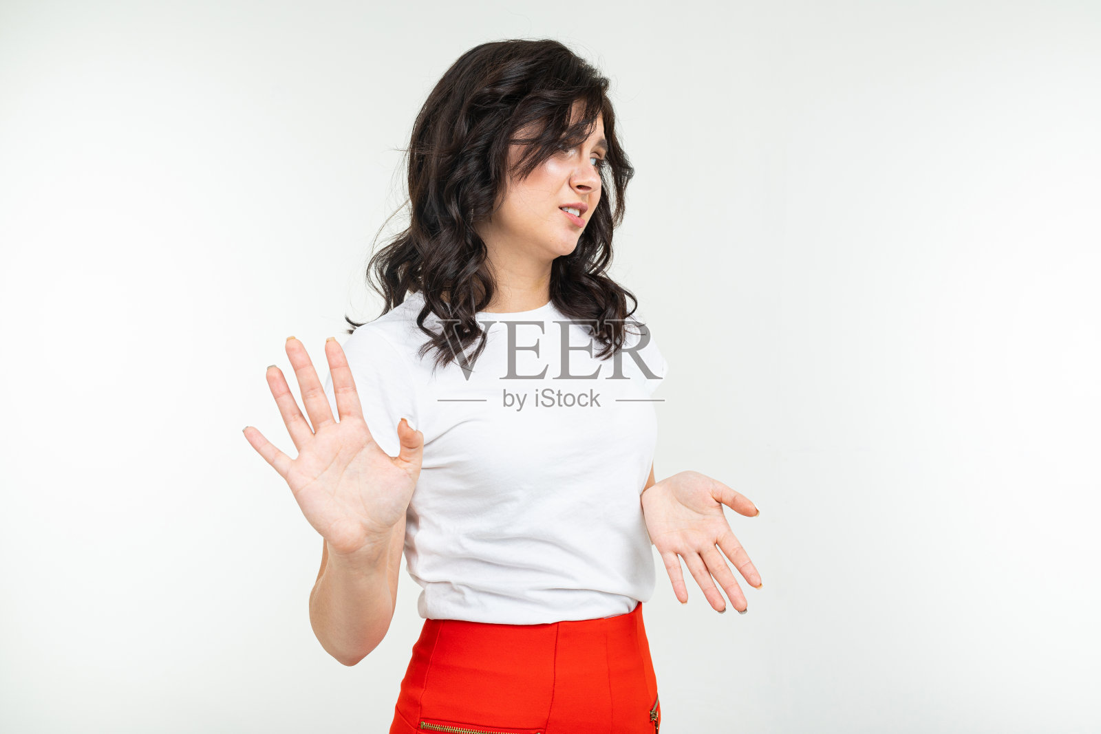 一个穿着白色t恤的黑发女孩在一个白色的工作室背景上担心一个问题照片摄影图片