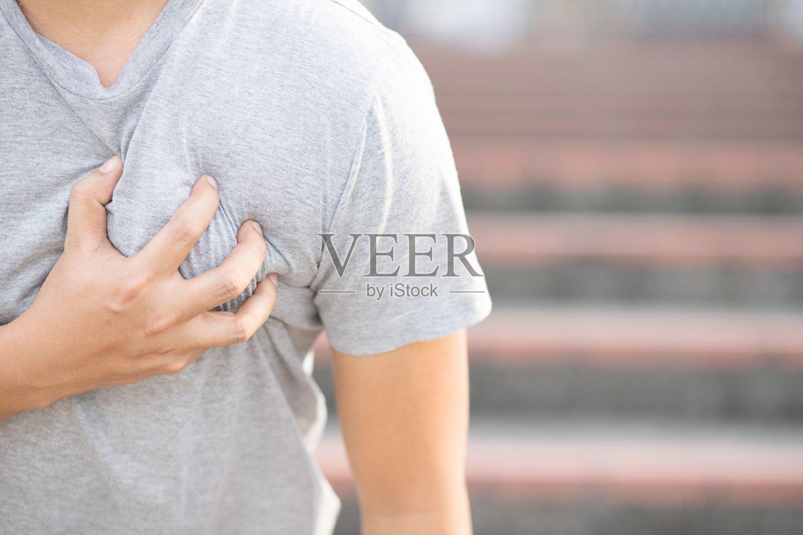 这个人的心在痛。心脏病发作照片摄影图片