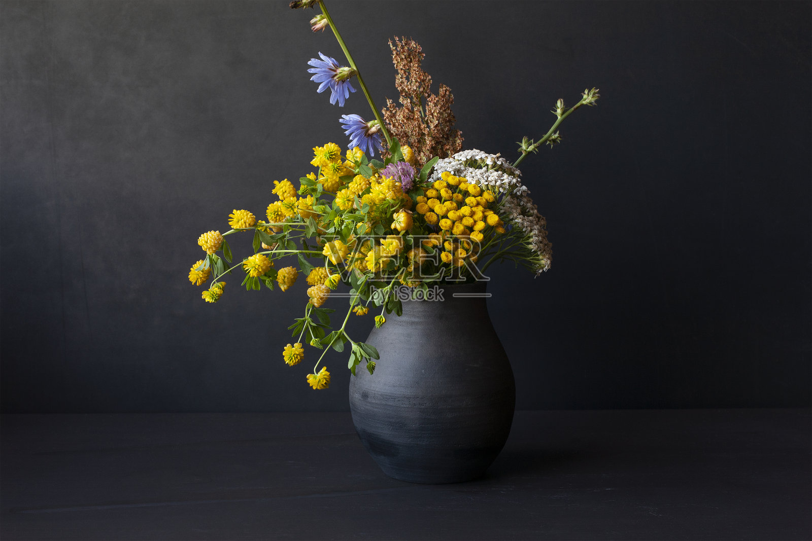 黑色陶瓷花瓶里的一束野花照片摄影图片