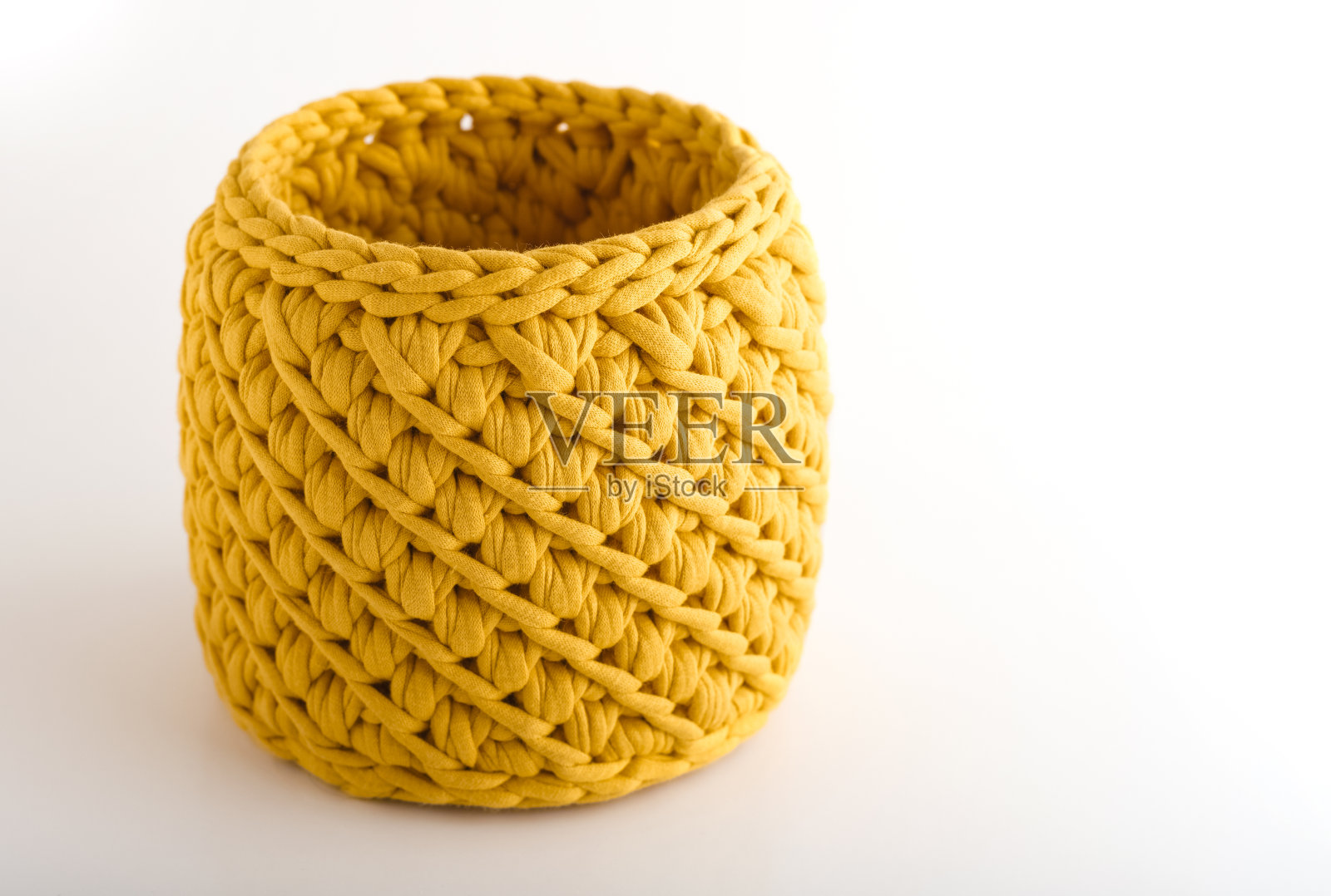 黄色手工篮子在白色背景，与文字的地方。编织织物的纹理照片摄影图片