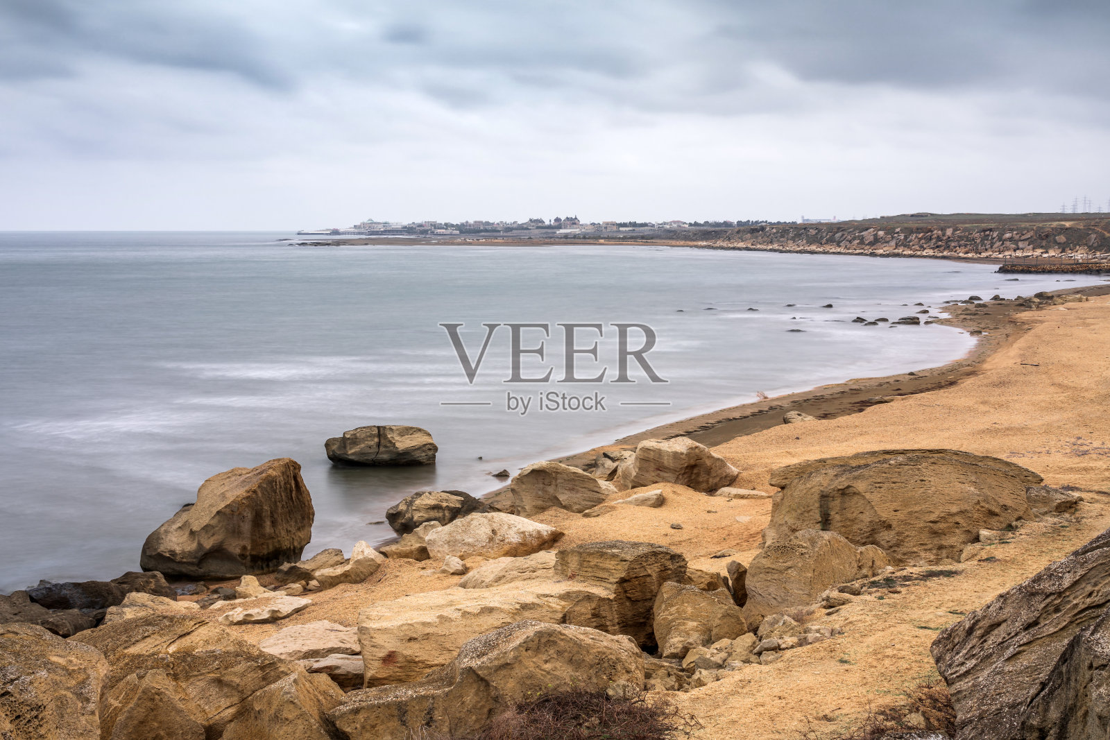 多云天气的岩石海滩照片摄影图片