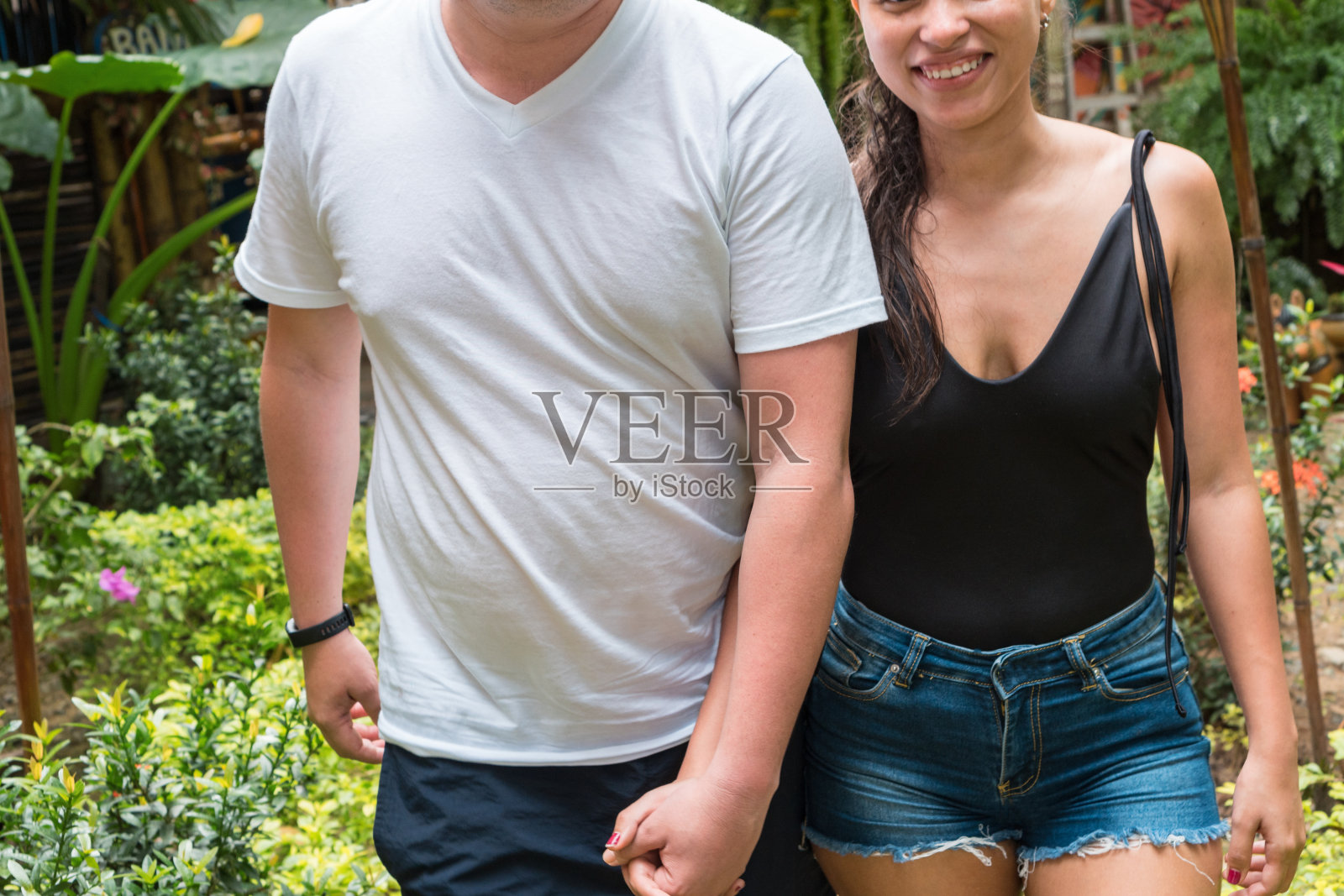 相爱的情侣手牵着手在公园里散步照片摄影图片