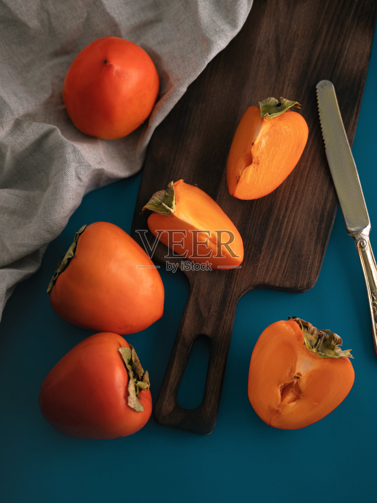 蓝色的桌子上放着柿子照片摄影图片