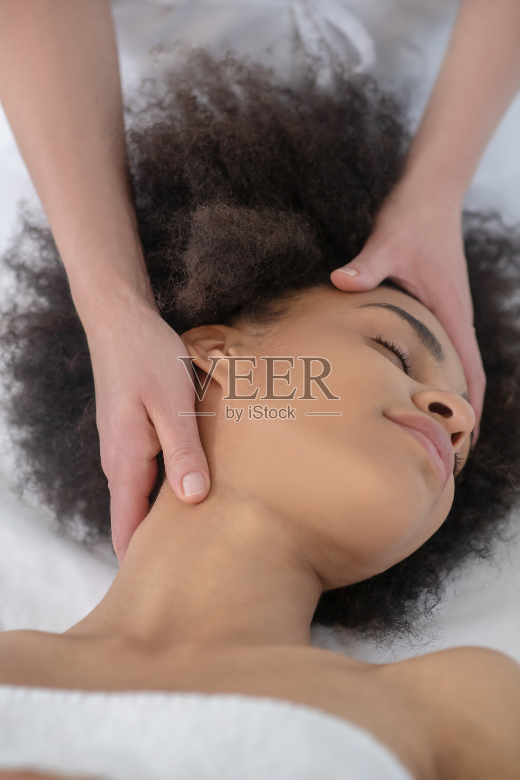 美容师的手靠近放松的女孩的脸照片摄影图片