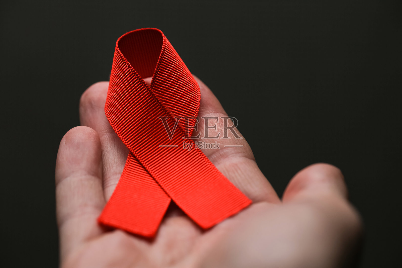AID红丝带在手，灰点上照片摄影图片