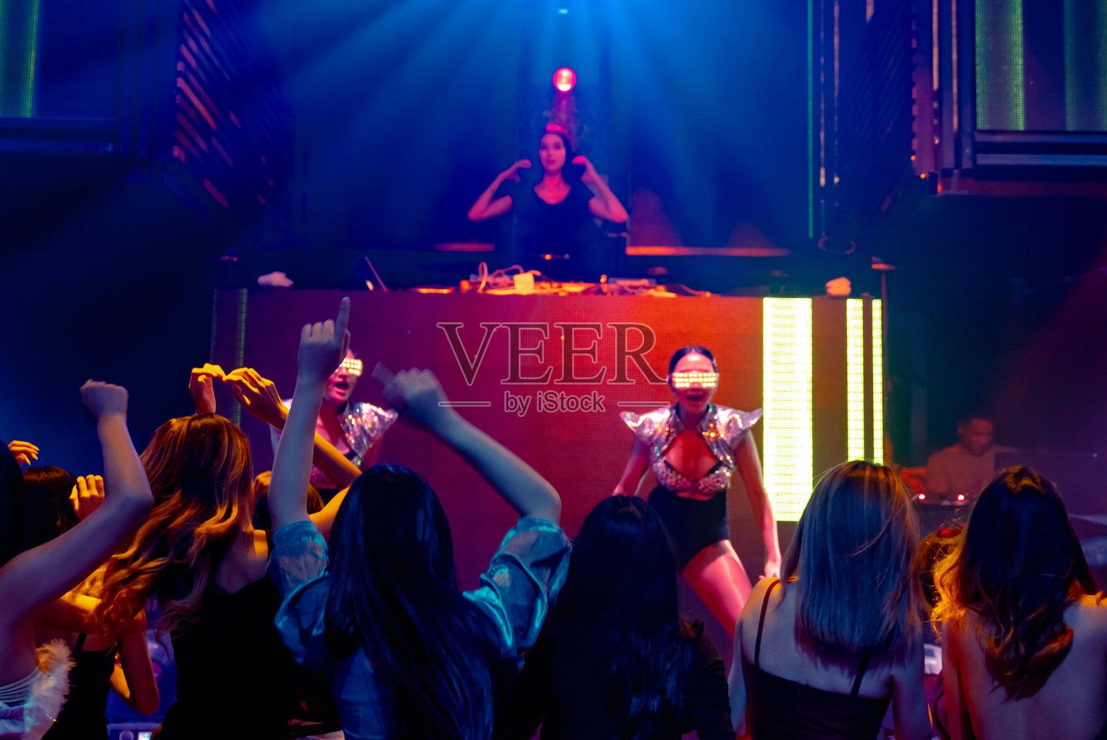 一群人在迪斯科夜总会随着DJ的音乐节奏跳舞照片摄影图片