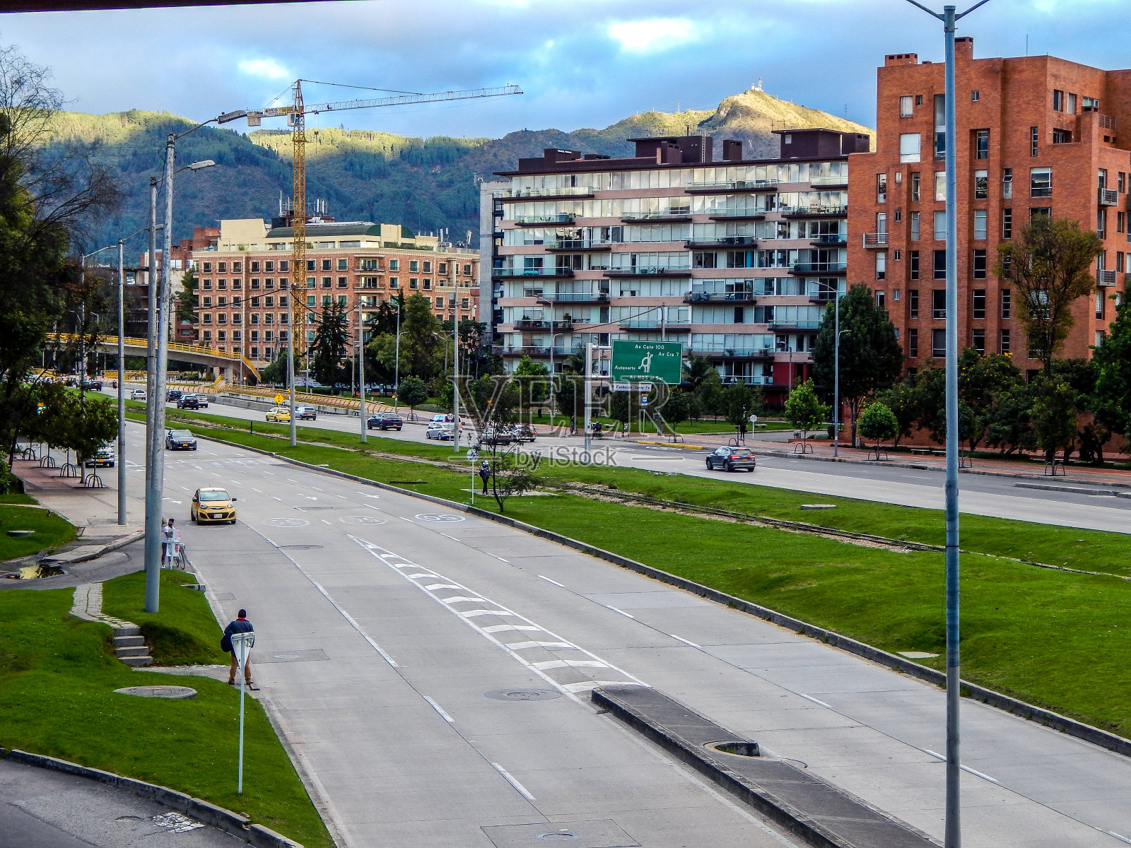 波哥大的街道，有汽车、建筑和铁路，背景是山脉照片摄影图片