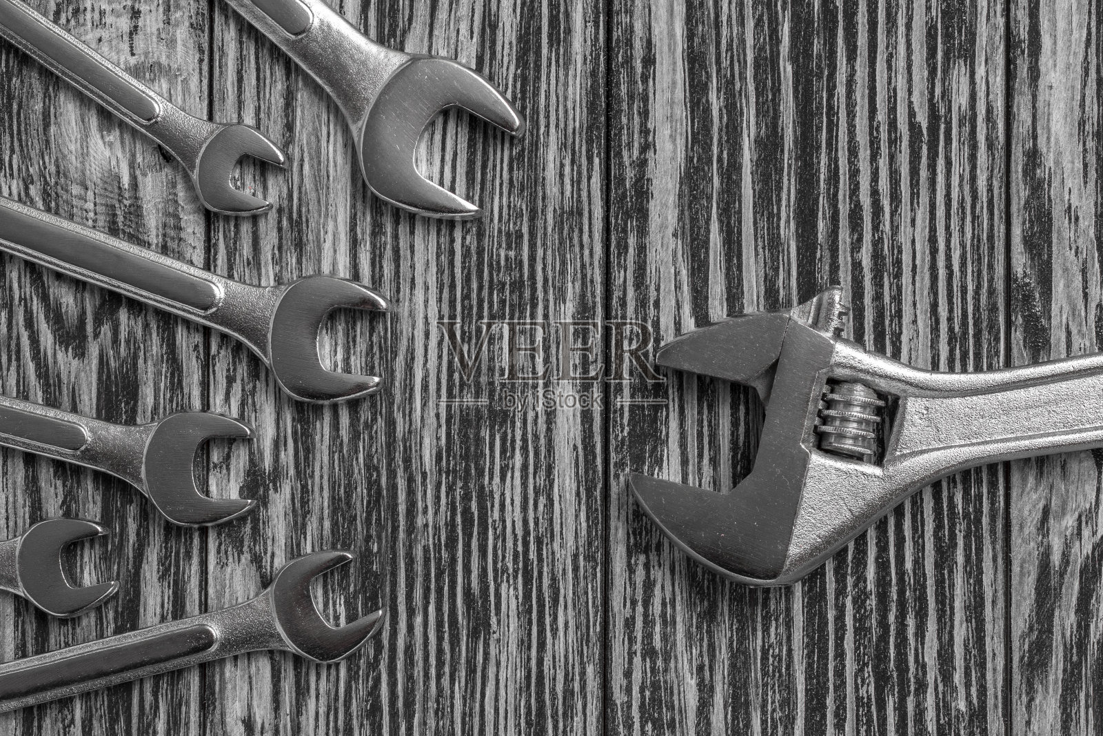 木制桌子上的扳手和可调扳手。照片摄影图片