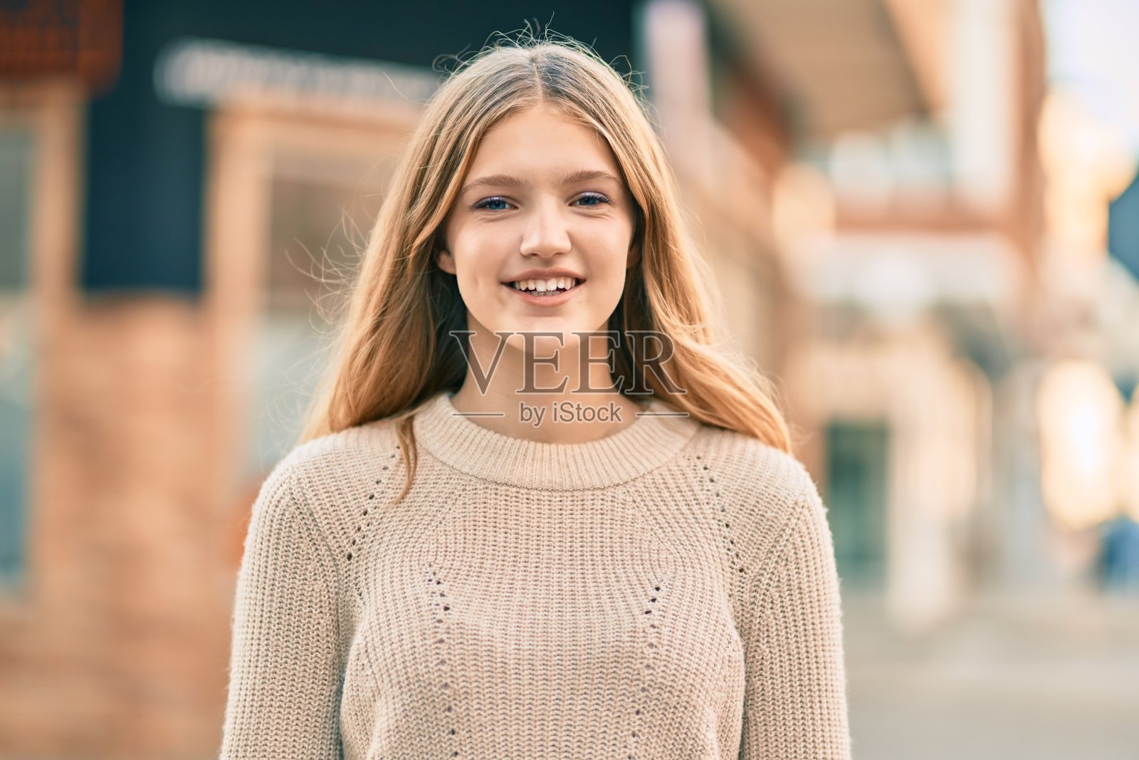 美丽的白人少年微笑着幸福地站在城市。照片摄影图片