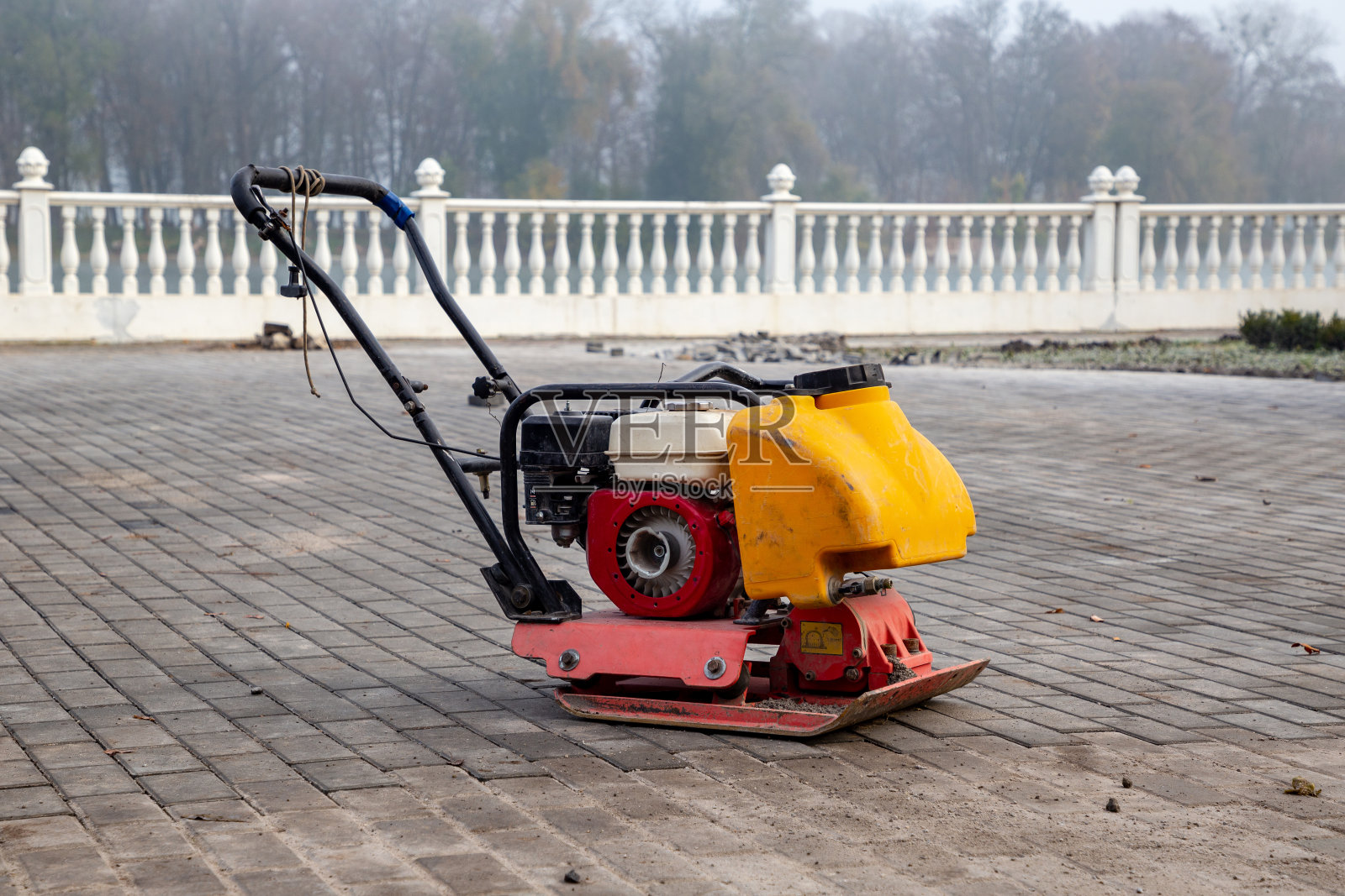 某建筑工地的振动板压实机。土壤血栓形成设备。用沙子、泥土或沥青压实的工作照片摄影图片