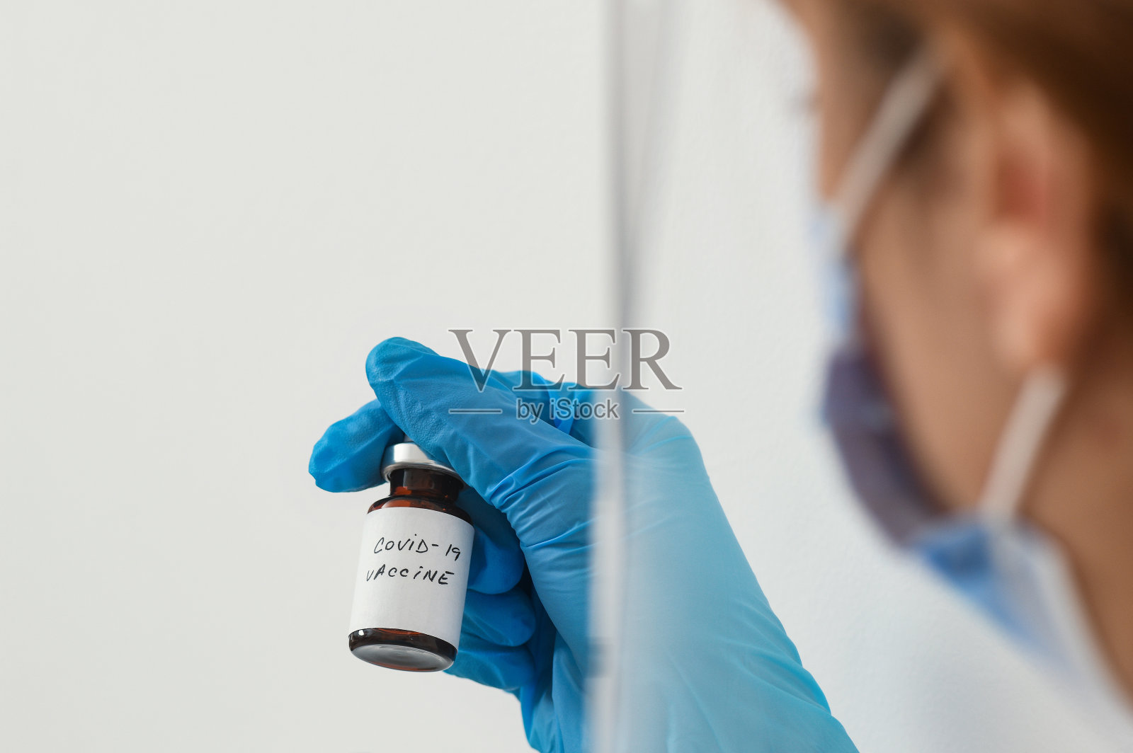 手持冠状病毒疫苗的女医生——covid-19健康理念照片摄影图片