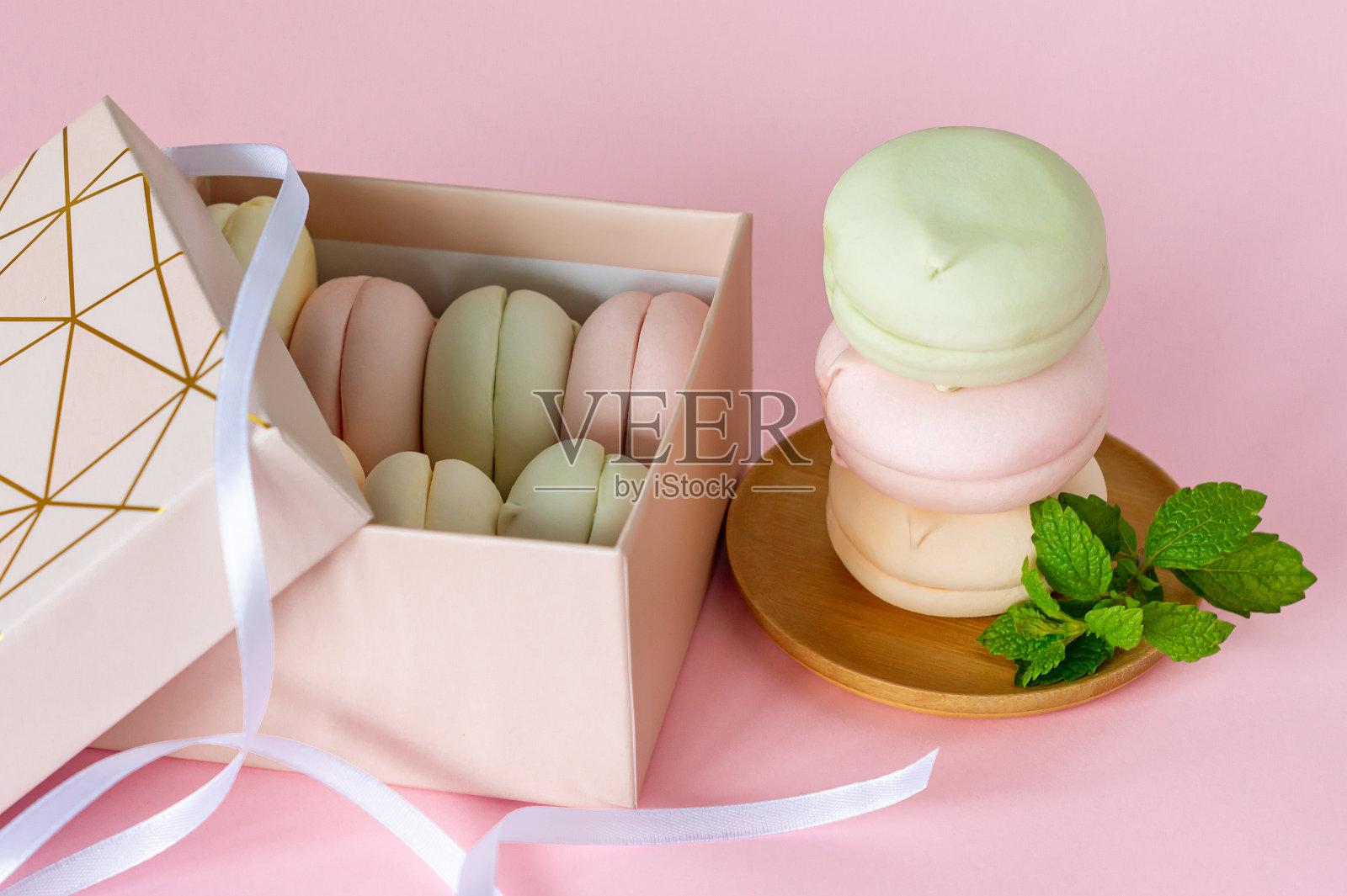 自制彩色彩色棉花糖礼盒。苹果和风呈圆形。美味的水果甜点在粉红色的背景照片摄影图片