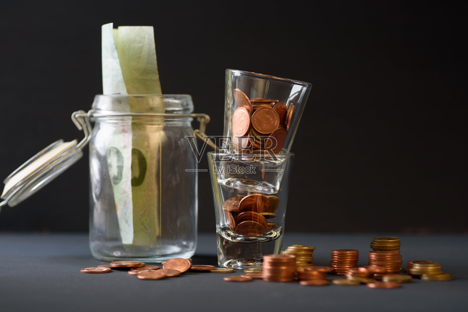 硬币是堆放在玻璃上的黑色背景。照片摄影图片