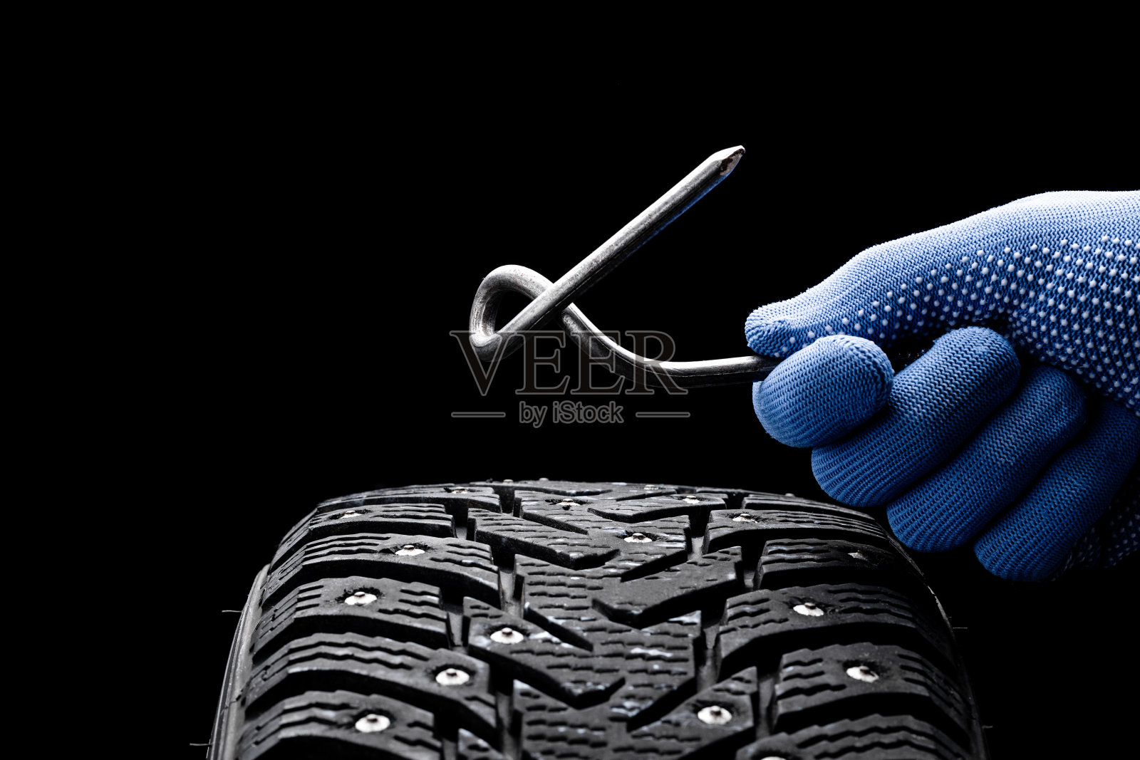 机械工人在黑色背景上修理轮胎钉。副本的空间。轮服务理念照片摄影图片