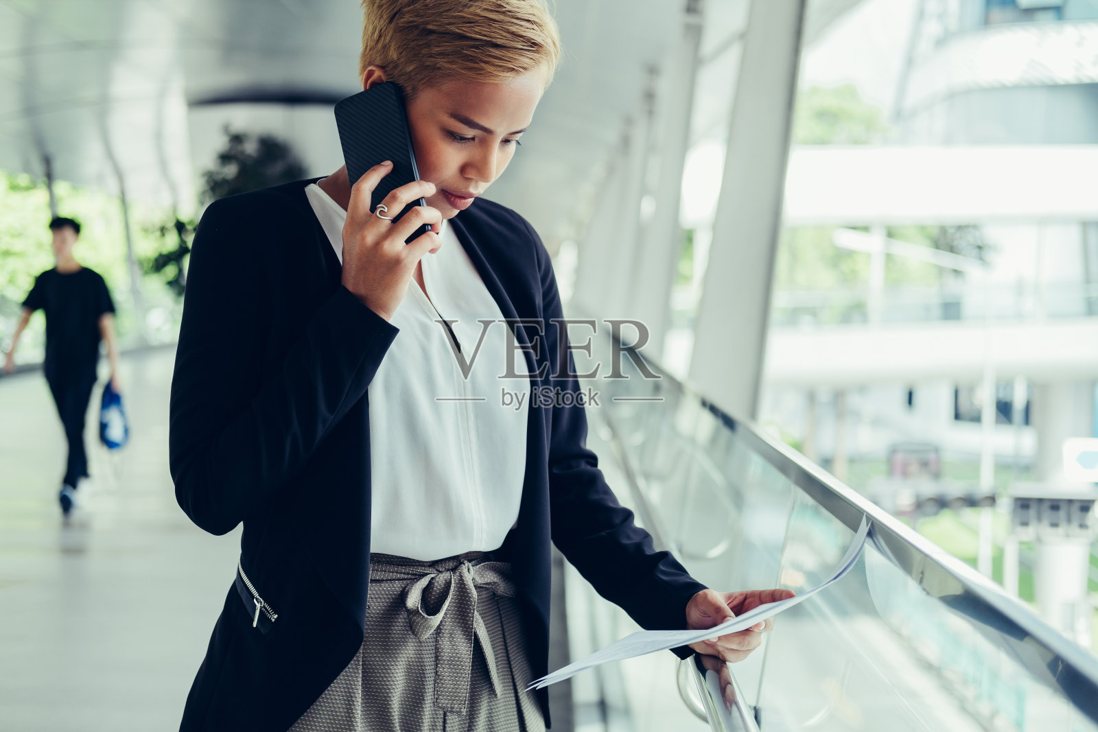 打电话看商业报纸的女商人照片摄影图片