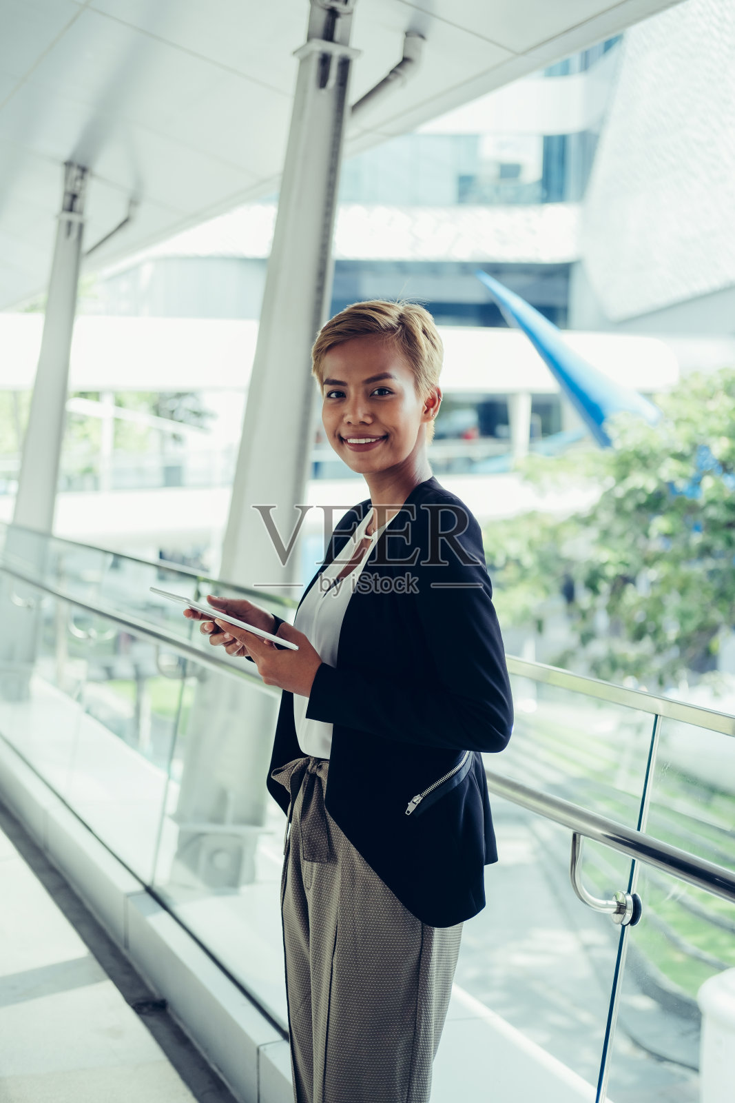 女商人拿着平板电脑看着相机照片摄影图片