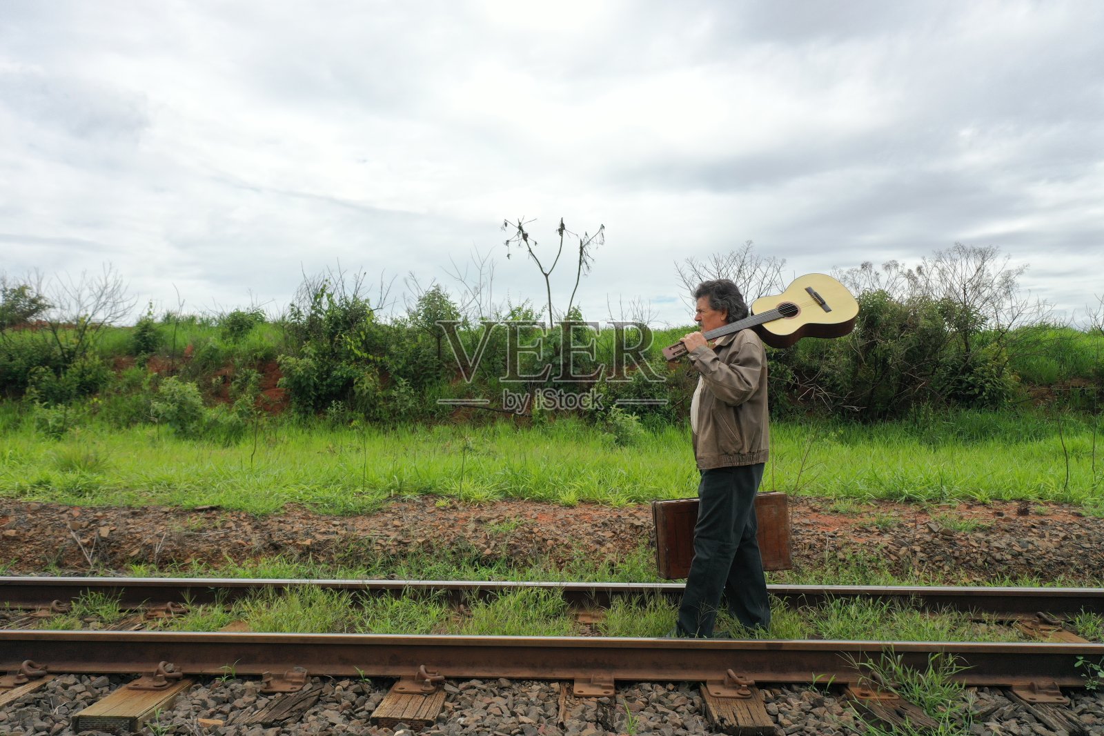 一位老人在铁路上行走照片摄影图片