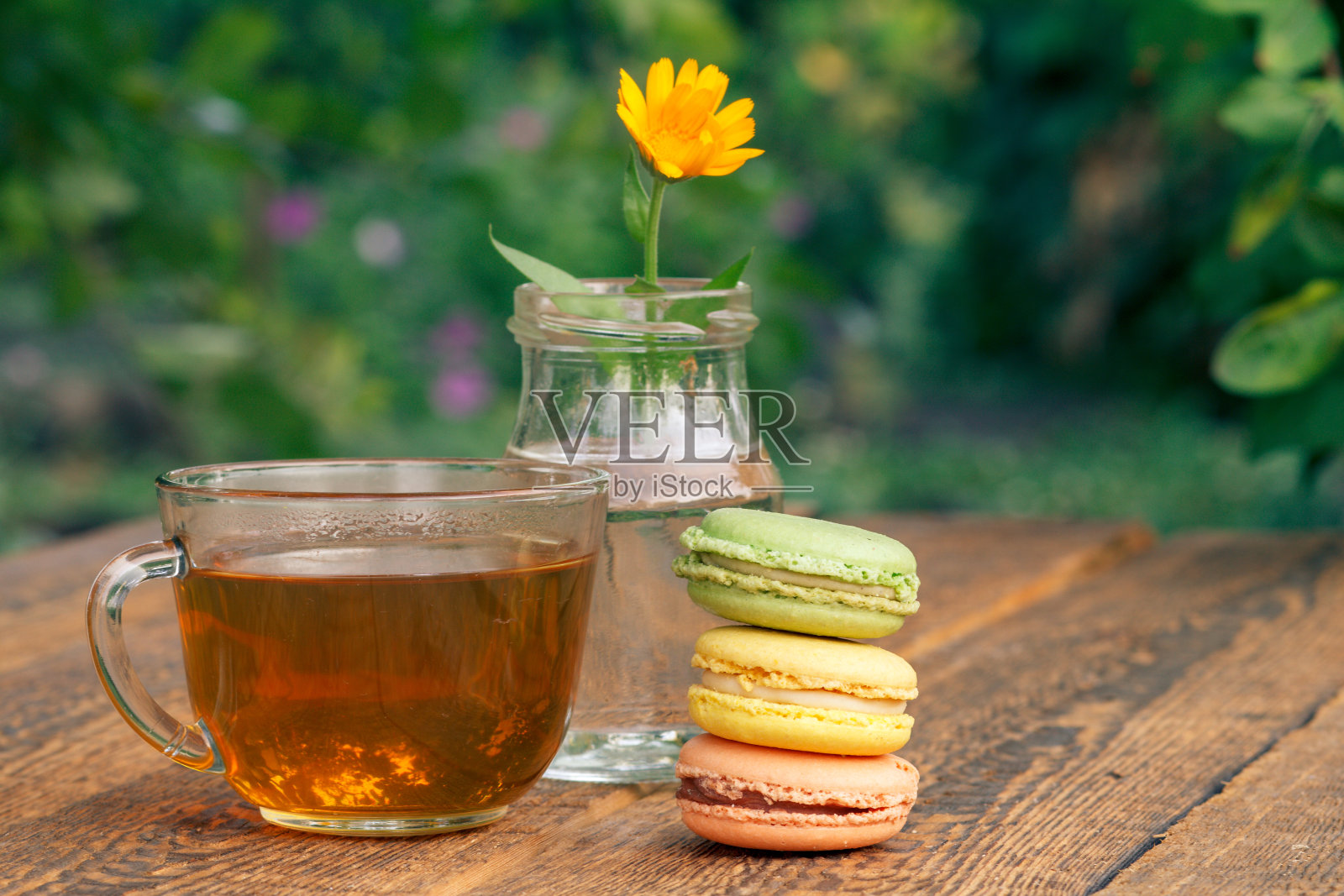 美味的杏仁饼，金盏花和一杯绿茶照片摄影图片