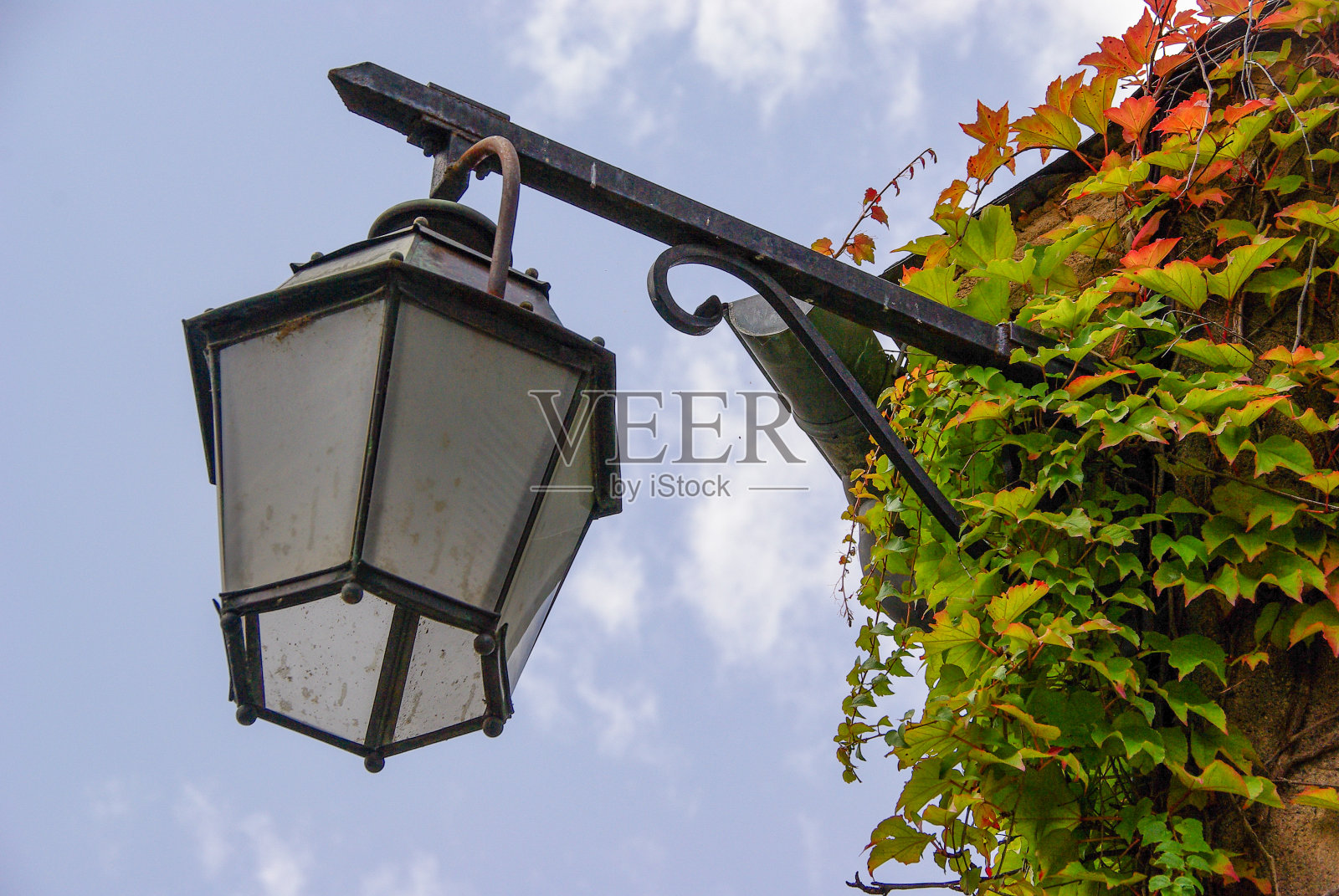 阴云密布的天空下，挂满野酒的屋角上的灯笼照片摄影图片