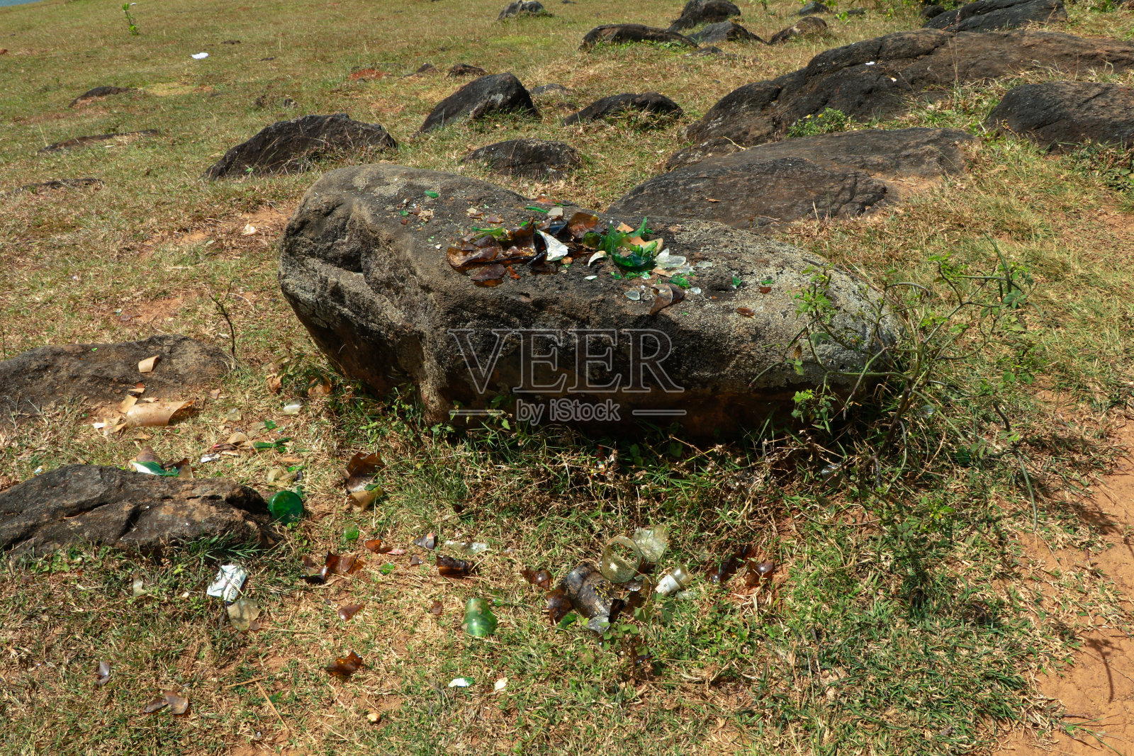 野餐地点岩石上的破啤酒瓶照片摄影图片