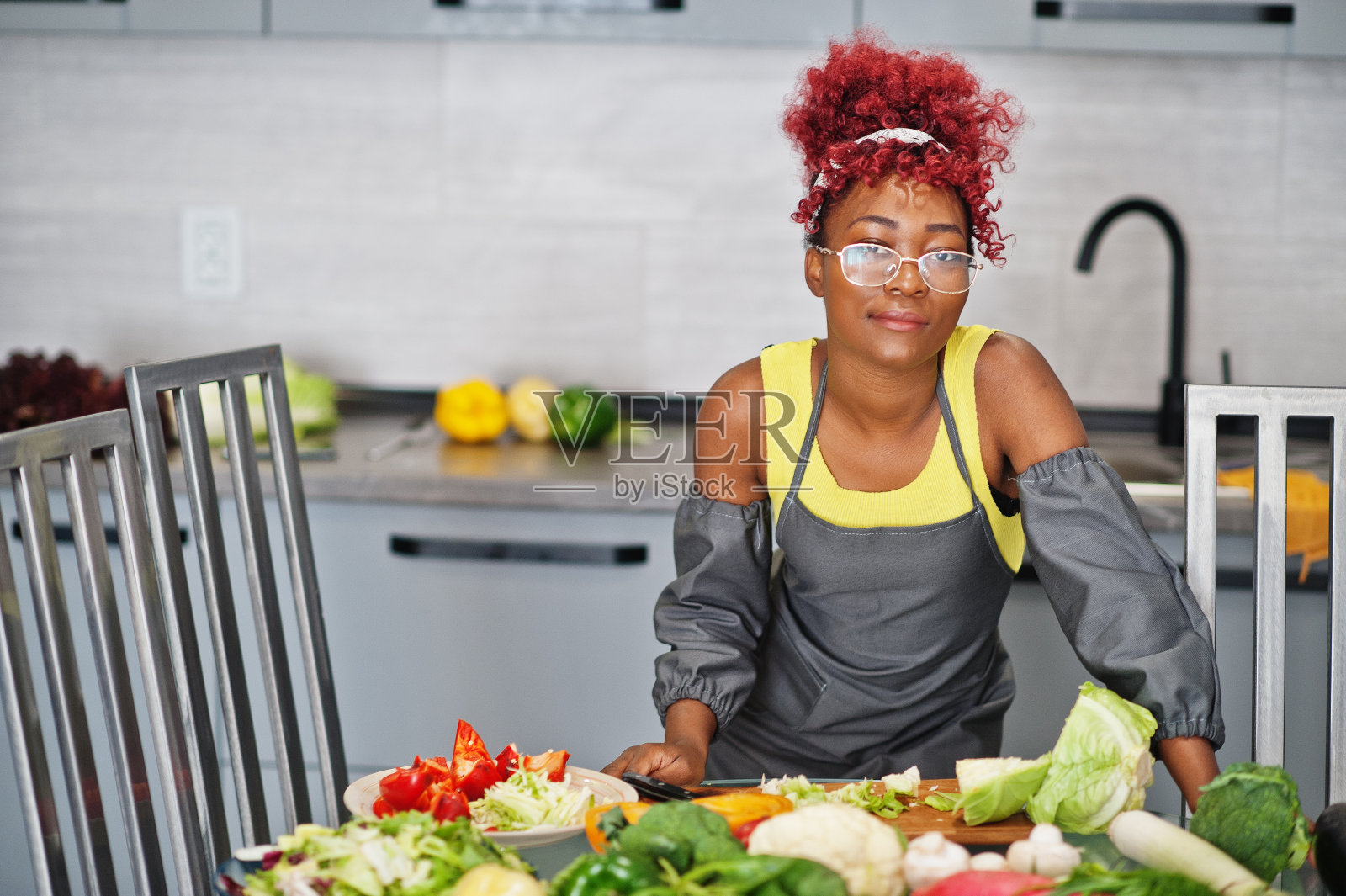 非洲裔美国妇女拍摄她的博客广播关于家庭厨房的健康食品。照片摄影图片