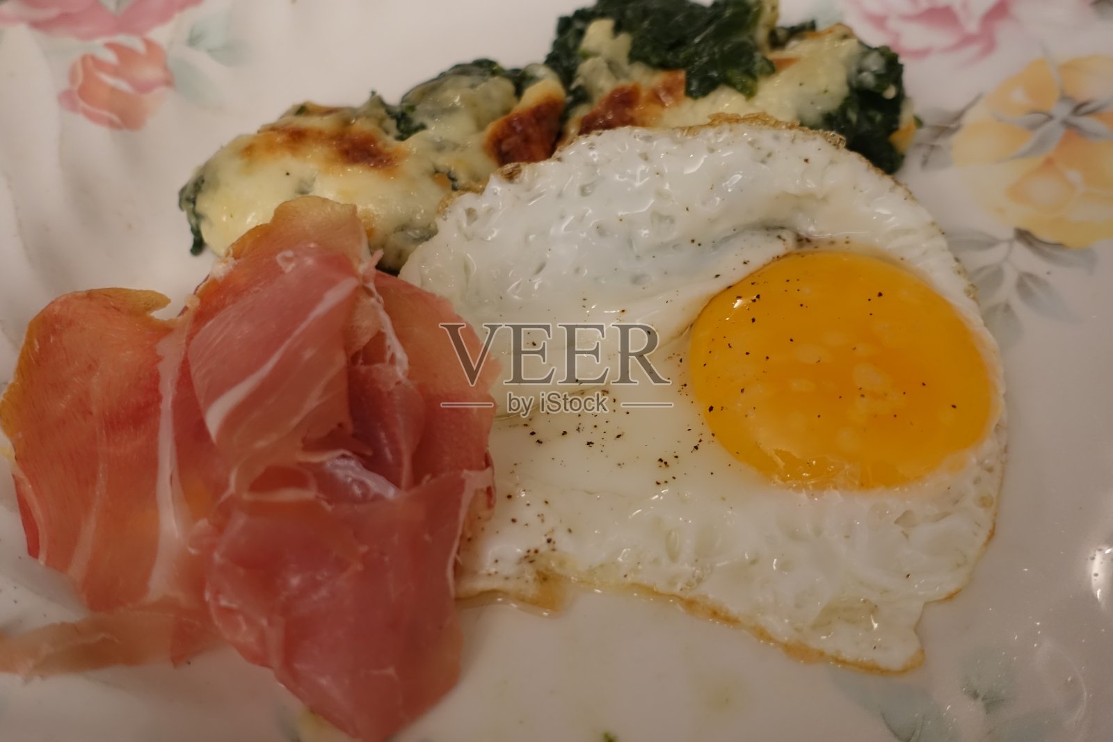 煎蛋和生火腿片，配以béchamel酱汁烤菠菜照片摄影图片