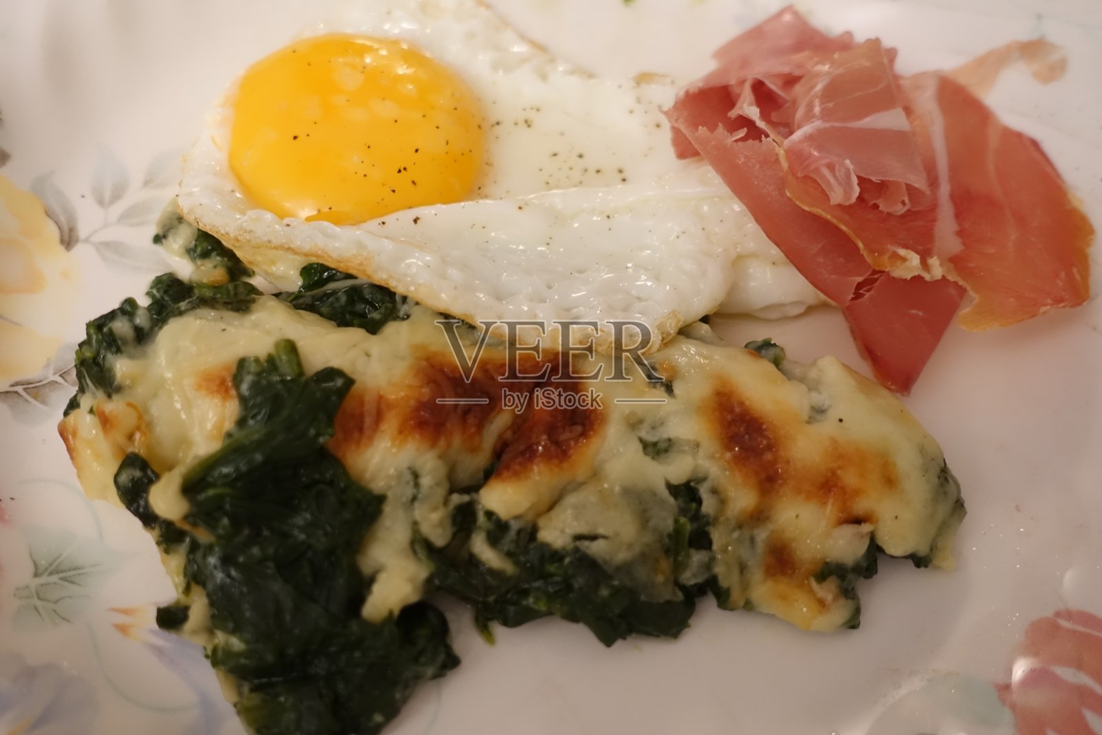 煎蛋和生火腿片，配以béchamel酱汁烤菠菜照片摄影图片