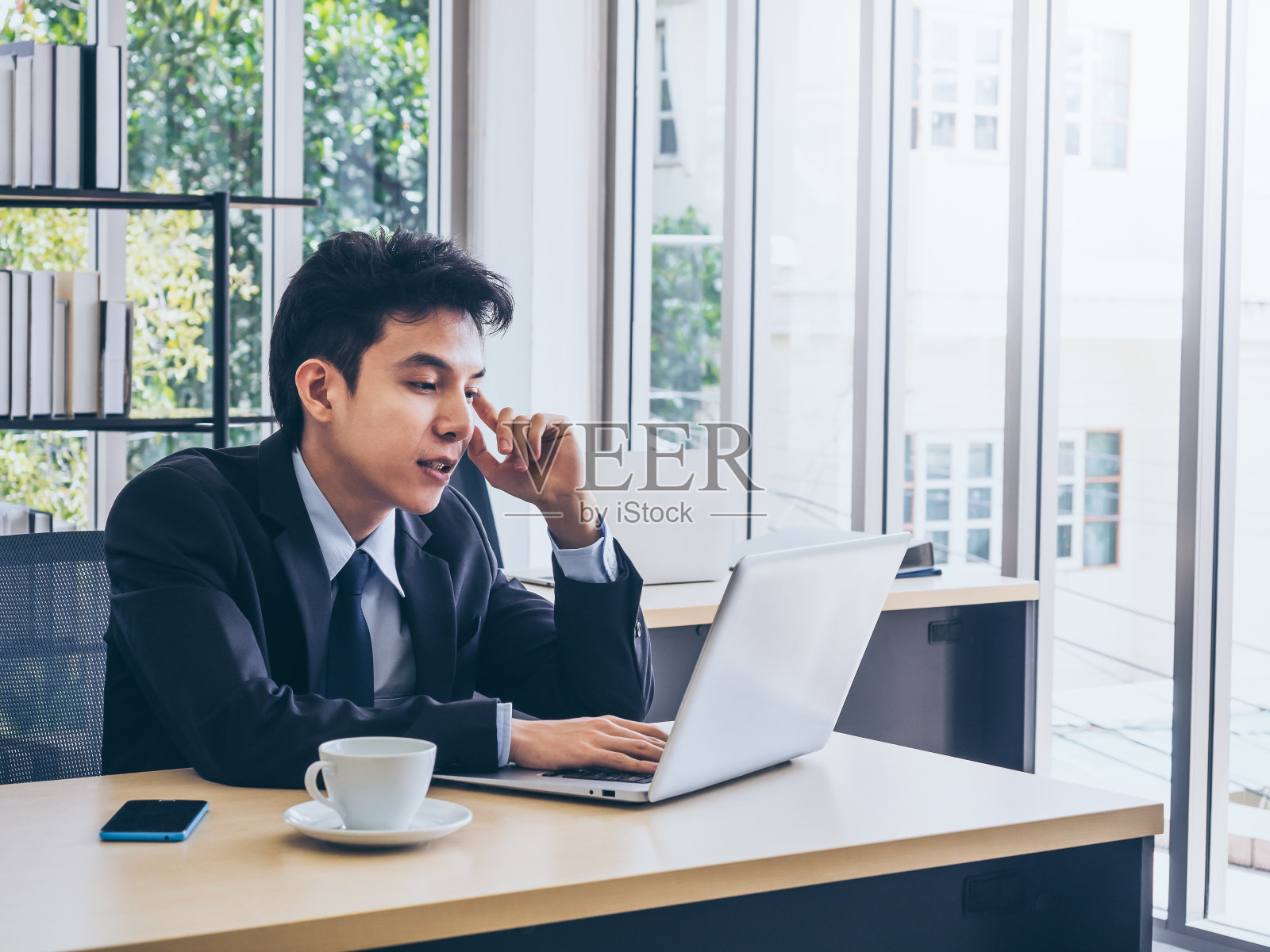 年轻英俊的亚洲商人西装革履的办公室。照片摄影图片