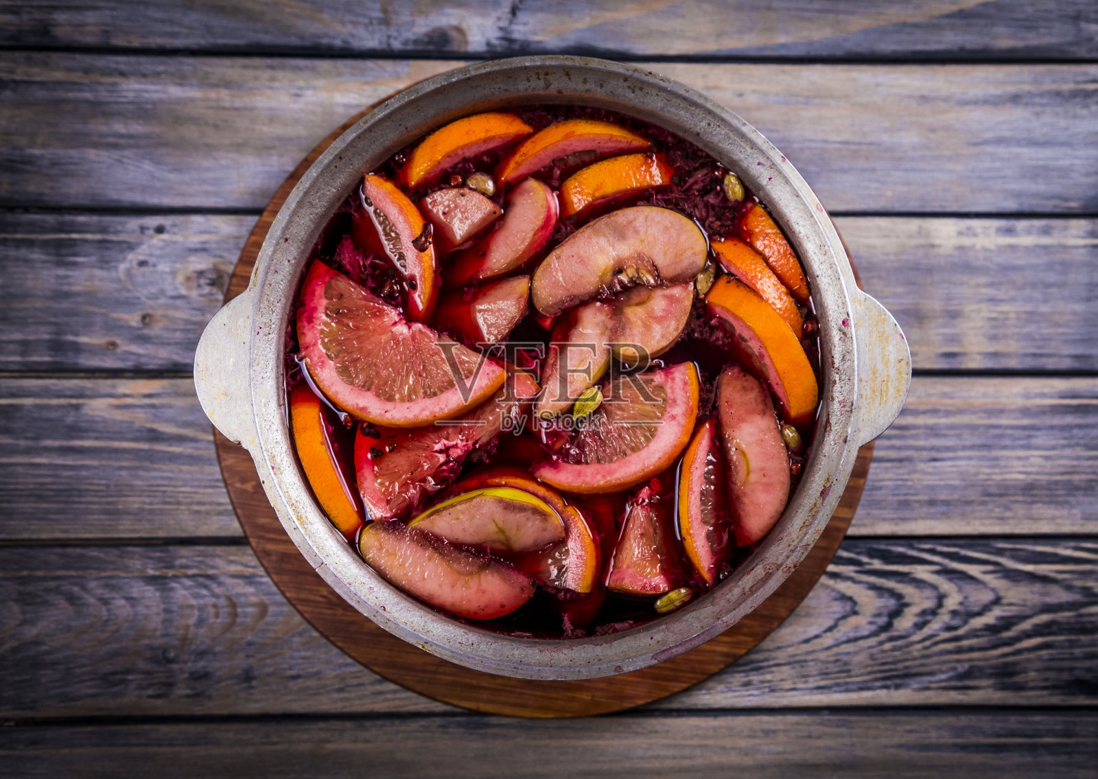 传统的热腾腾的圣诞饮料，热红酒，葡萄酒煮沸与苹果和柑橘木背景。圣诞晚会。照片摄影图片