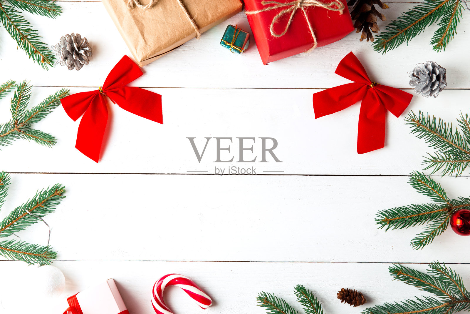 美丽的圣诞作文木制白色背景。圣诞礼物盒，雪枞树枝，松柏球果，焦糖棒，礼物。新年。俯视图，复制空间。照片摄影图片
