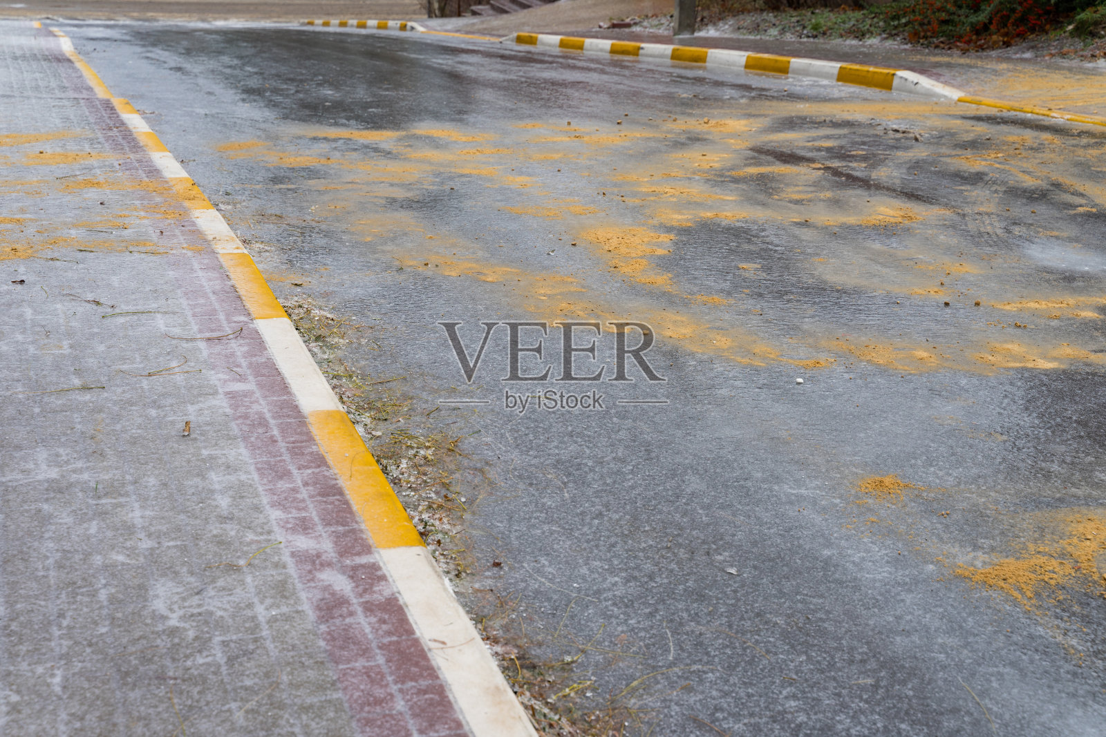 为了行人和汽车的安全行驶，在冰上撒上沙子和盐。照片摄影图片