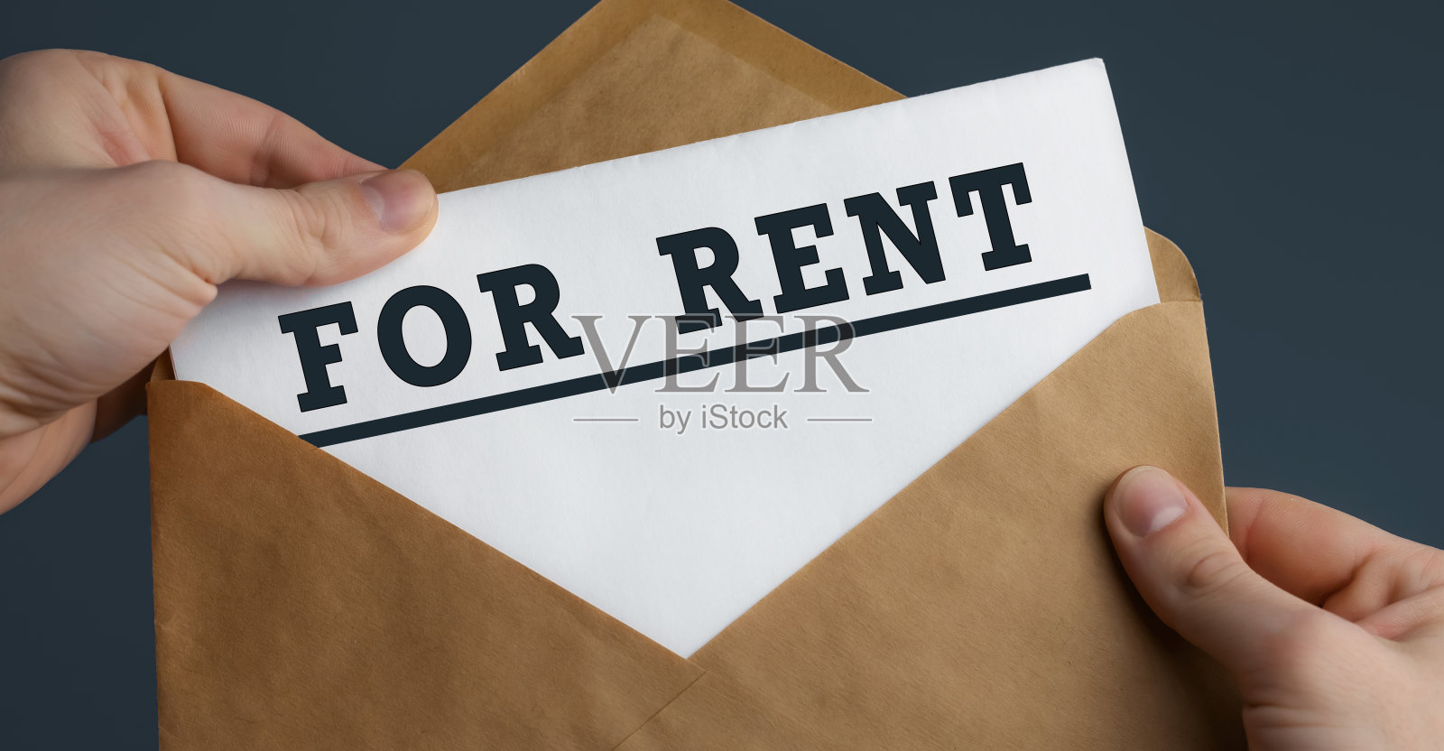 男人的手握工艺品信封与文字为出租在蓝色背景照片摄影图片