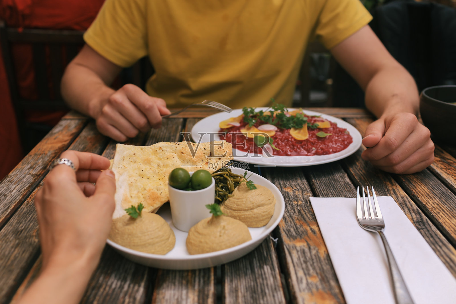 一对夫妇用鹰嘴豆泥和意大利调味饭吃午餐照片摄影图片