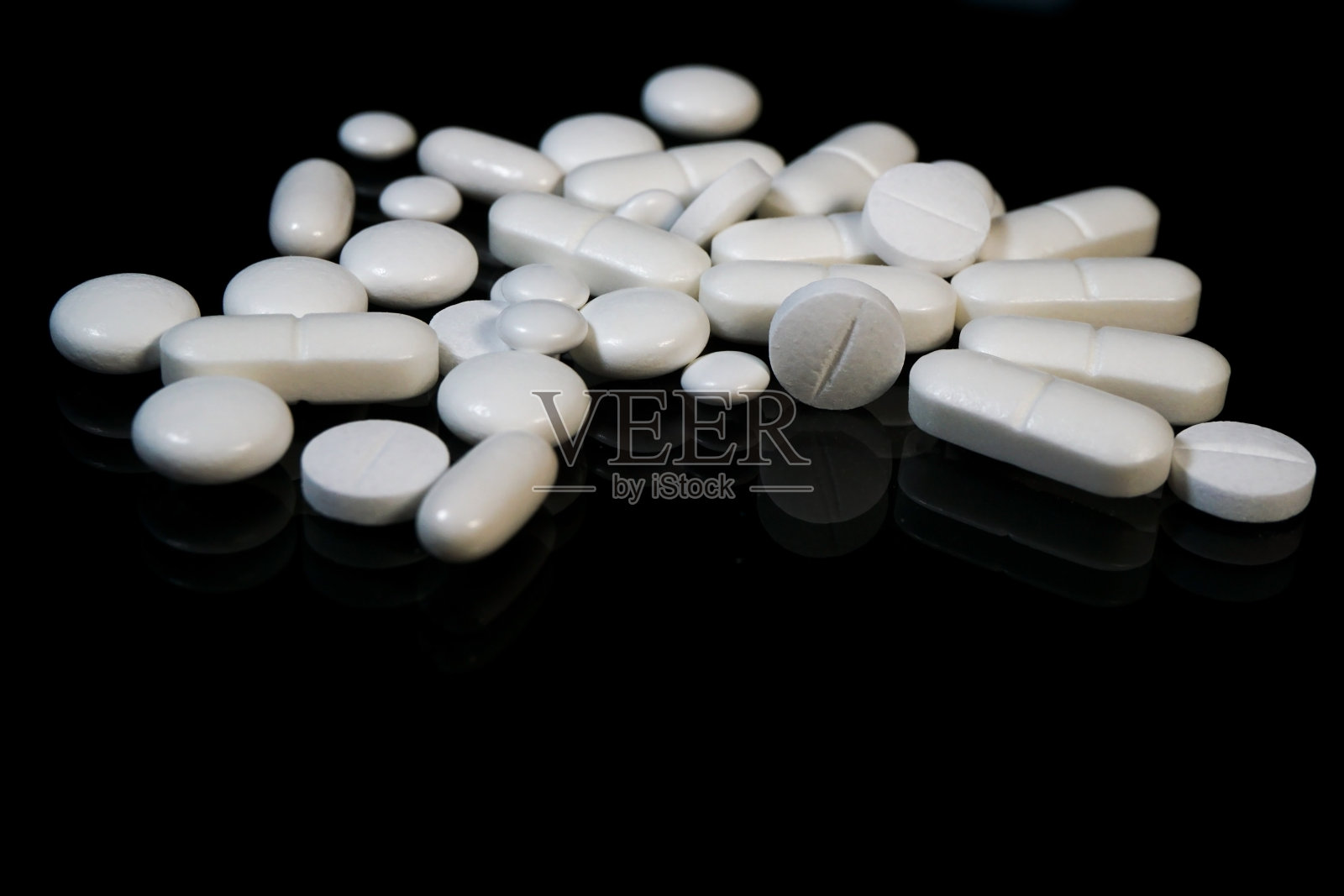 很多白色药丸的背景是黑色的照片摄影图片
