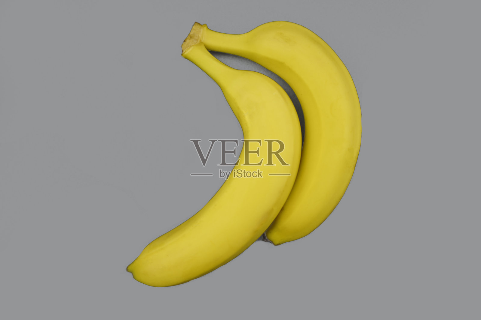 灰色背景上的两根香蕉。照片摄影图片
