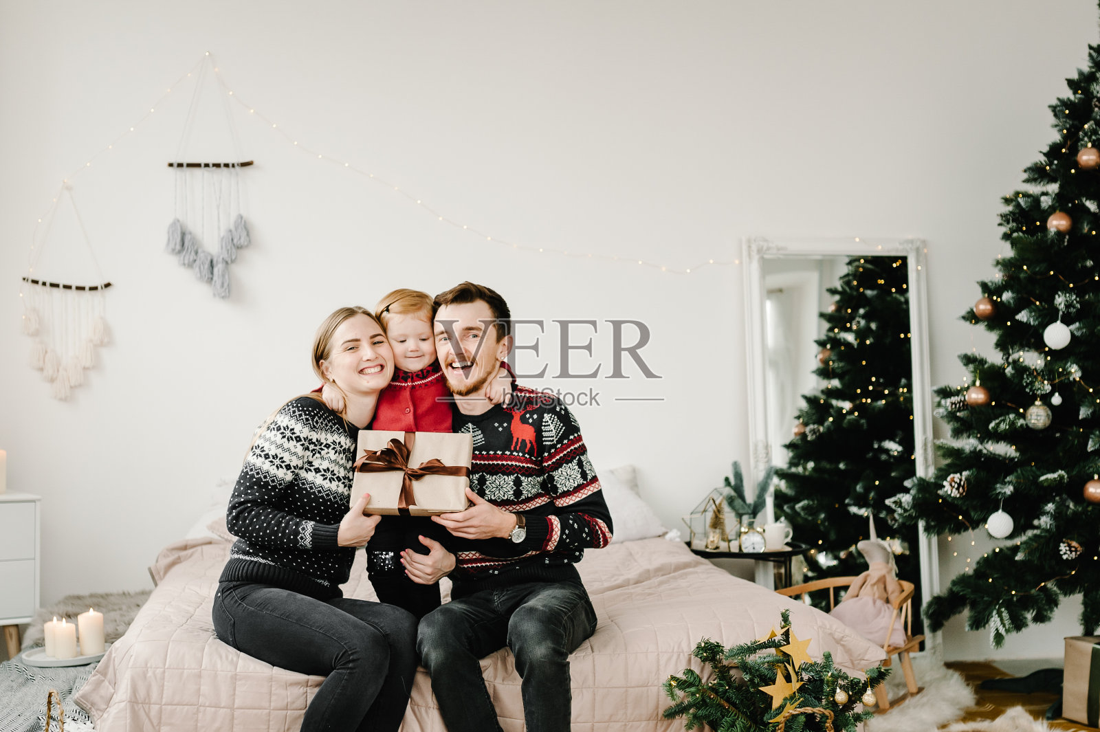 圣诞节家人拥抱。孩子送了一份圣诞礼物给他的父母一个惊喜。家人打开礼物礼盒。圣诞快乐，节日快乐。2021年新年快乐。照片摄影图片