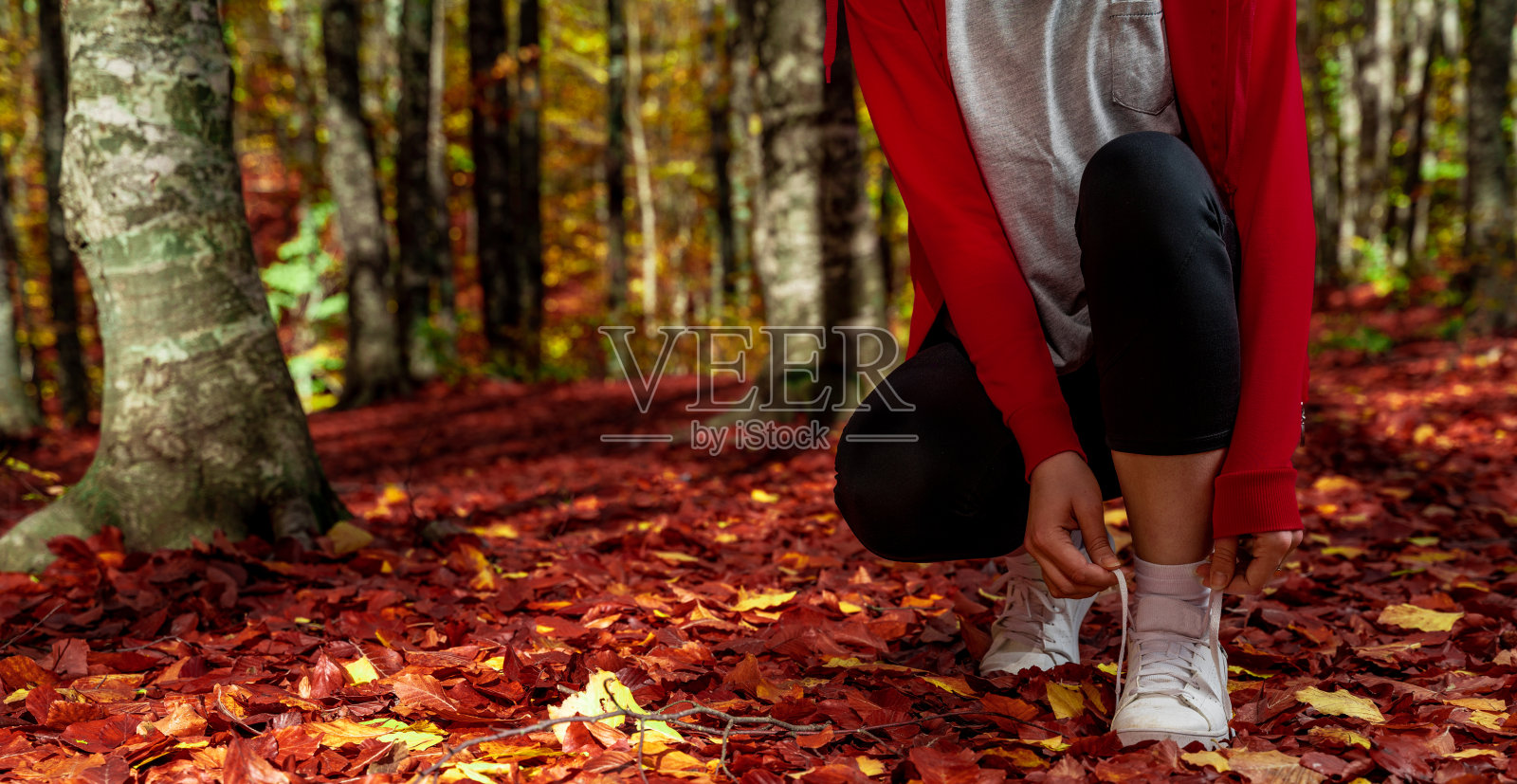 女人系着她运动鞋的鞋带照片摄影图片