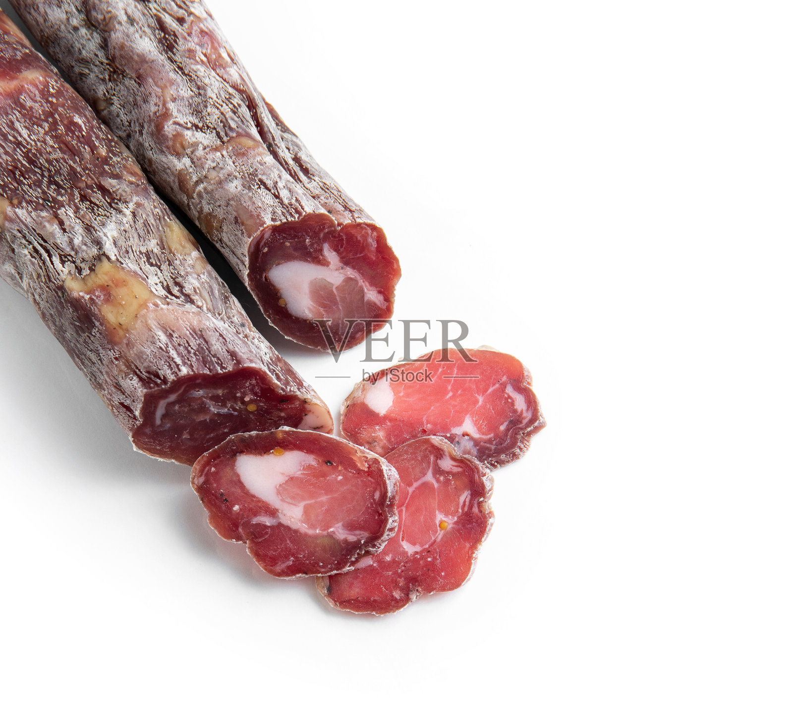 把干香肠切成片放在白色盘子上。精英的肉类产品。照片摄影图片