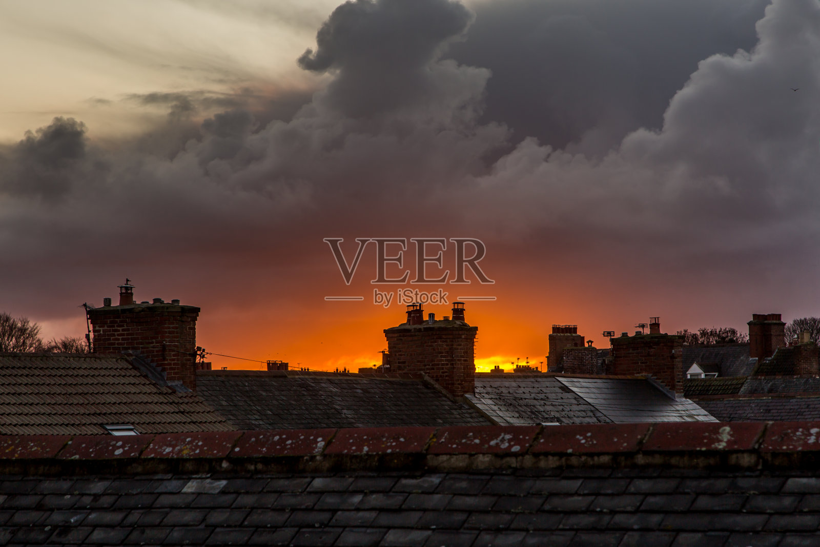 "日落时，乌云在屋顶上逼近"照片摄影图片