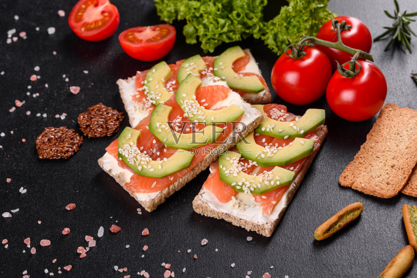 鲜嫩美味的三明治，搭配红鱼、黄油、面包和鳄梨照片摄影图片