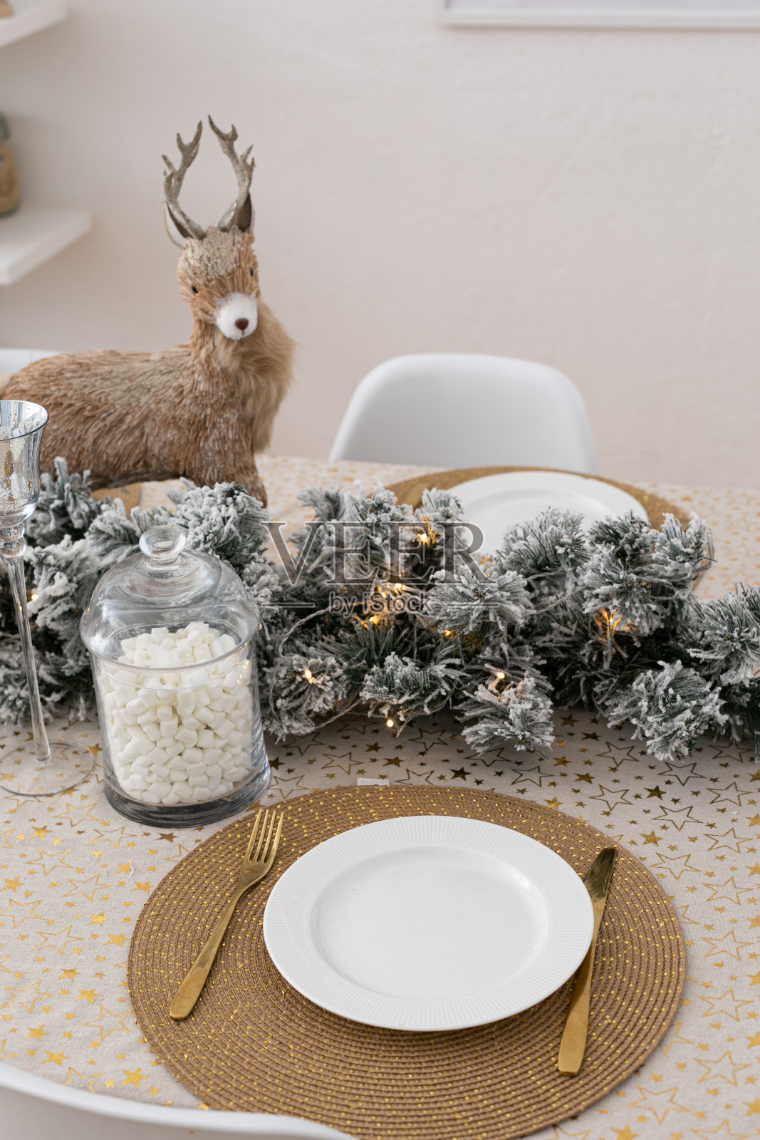 装饰圣诞餐桌没有食物。装饰有冷杉花环和金色的桌布和餐巾。节日的气氛中。庆祝新年或圣诞节。为节日装饰房子。照片摄影图片