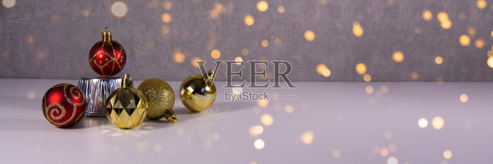 金色和红色的圣诞彩球在灰色的背景下闪闪发光照片摄影图片