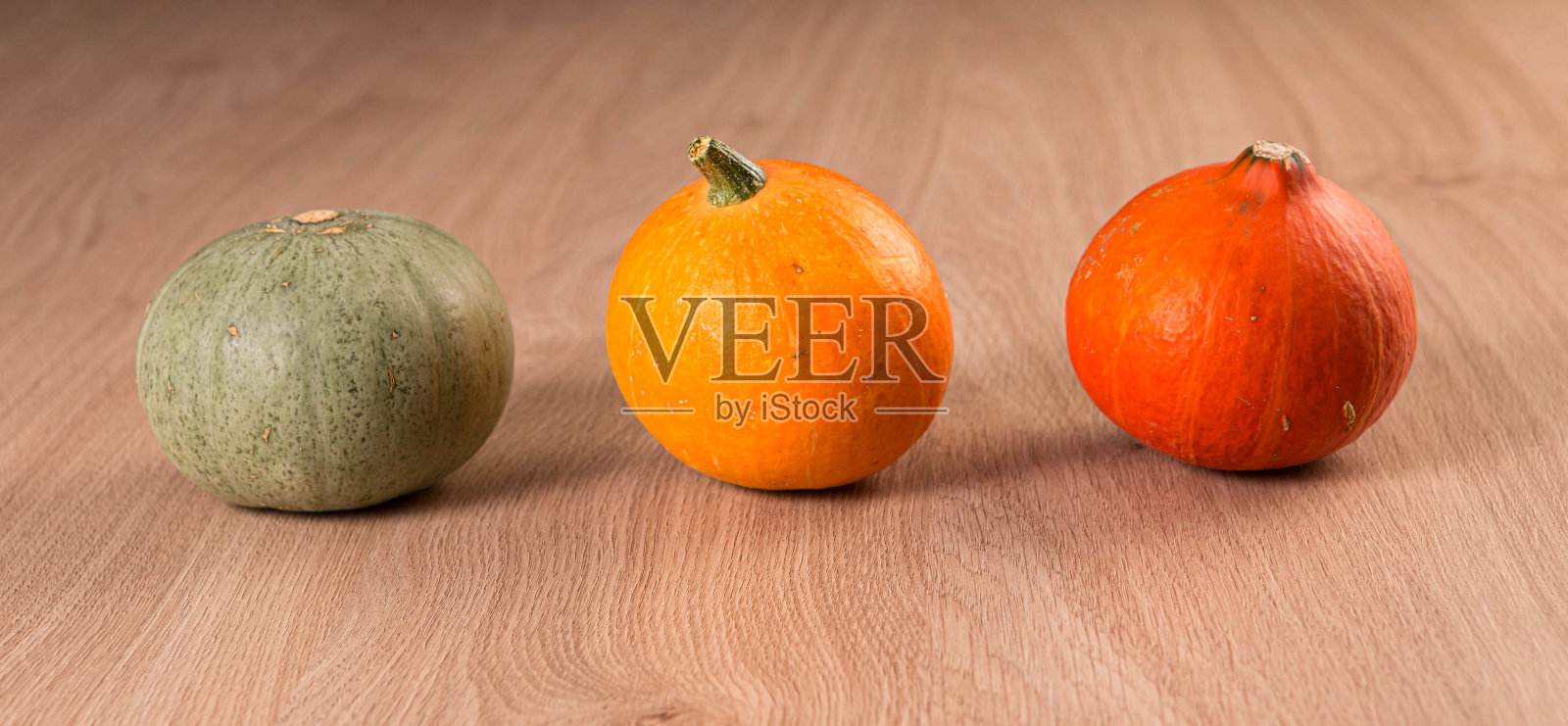 新鲜南瓜在木桌上排成一排，横幅。感恩节和万圣节的概念。照片摄影图片