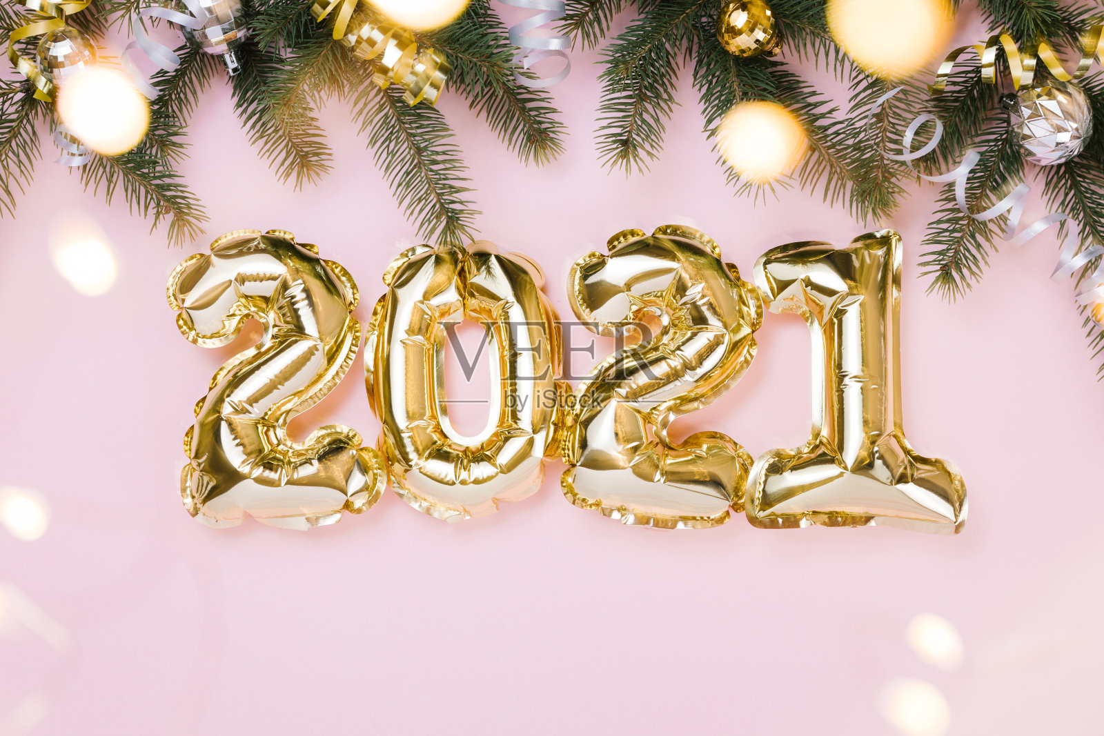 金箔气球数字2021和童话灯在柔和的粉红色背景。平铺，圣诞创意概念照片摄影图片