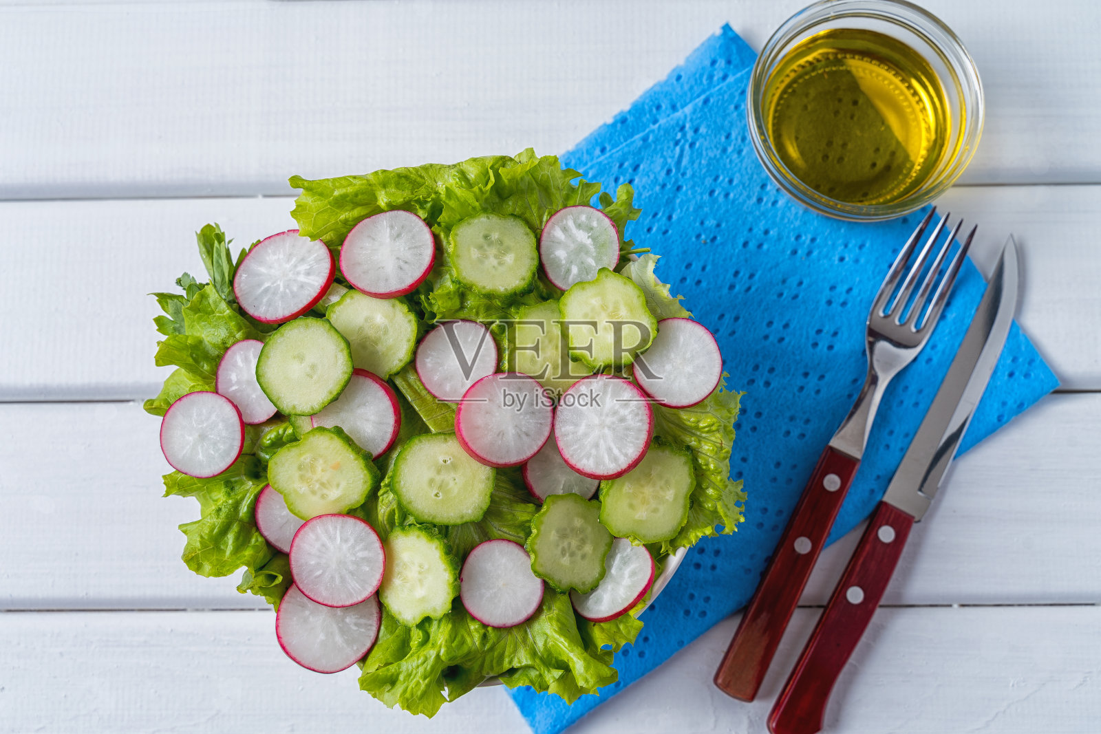 蔬菜沙拉与萝卜，黄瓜和生菜在一个沙拉碗，平铺。照片摄影图片
