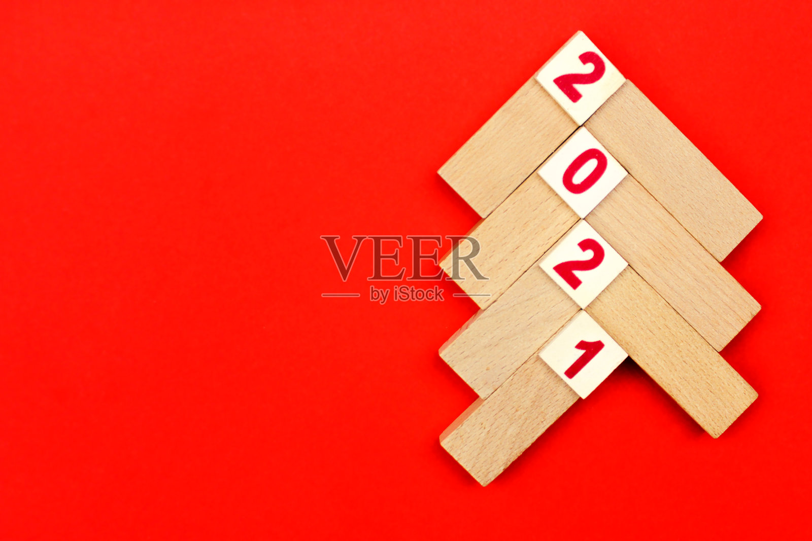 红色背景上印有“2021”字样的轻木条制成的圣诞树照片摄影图片