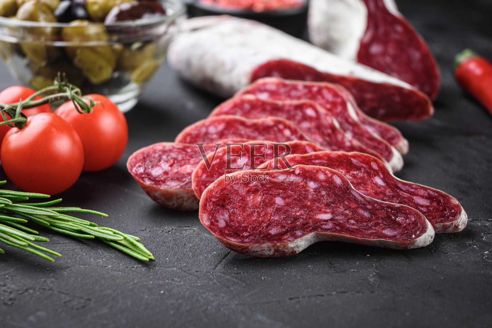 西班牙龙舌兰香肠片与香草在黑色背景照片摄影图片