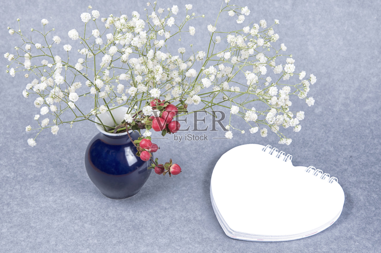 民间风格的情人节卡片。红色的浆果，心形，白色的冬季花朵，自然的灰色背景。模型，拷贝空间，文本。照片摄影图片