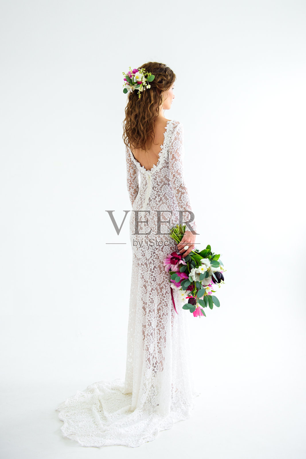 快乐的少女新娘身穿白色针织连衣裙，手捧一束鲜花照片摄影图片