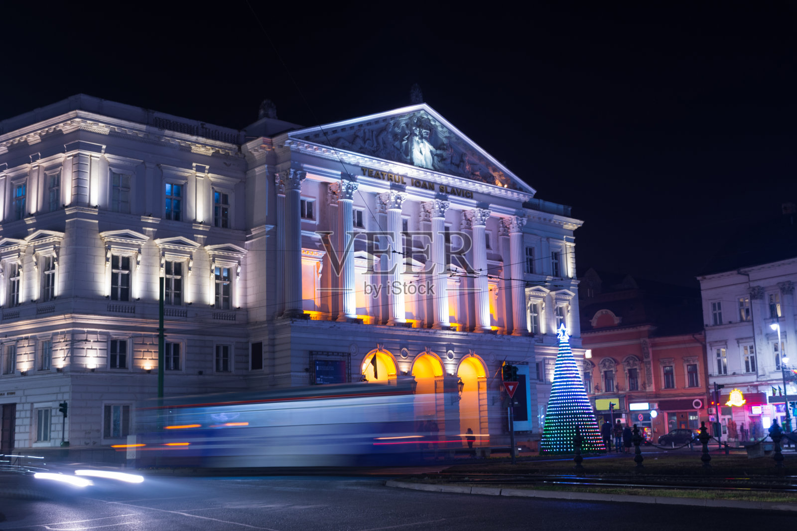 罗马尼亚阿拉德市中心，晚上长时间暴露在交通信号灯、圣诞树和冬季装饰下。照片摄影图片